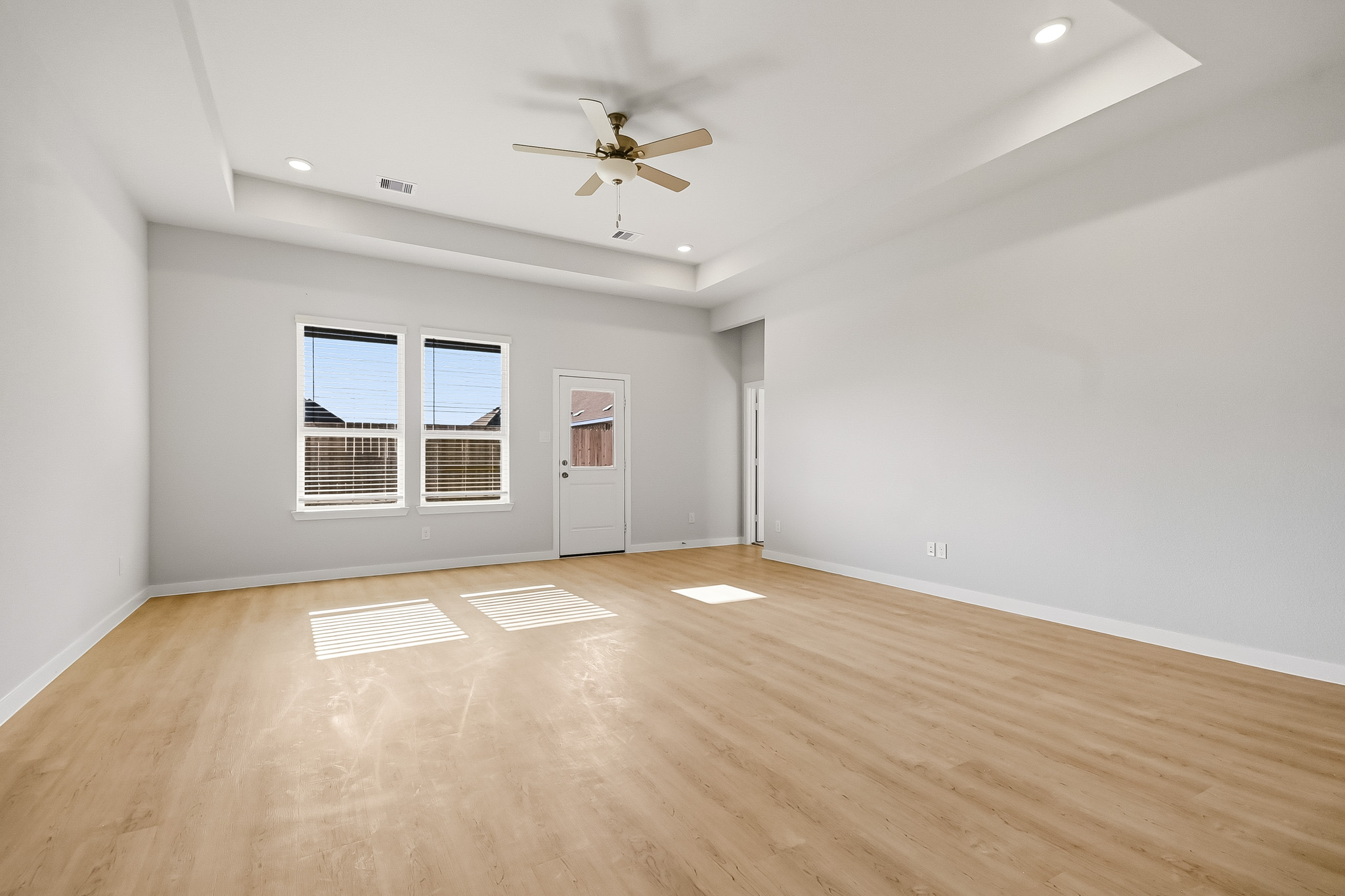 A room with a wood floor and a ceiling fan.