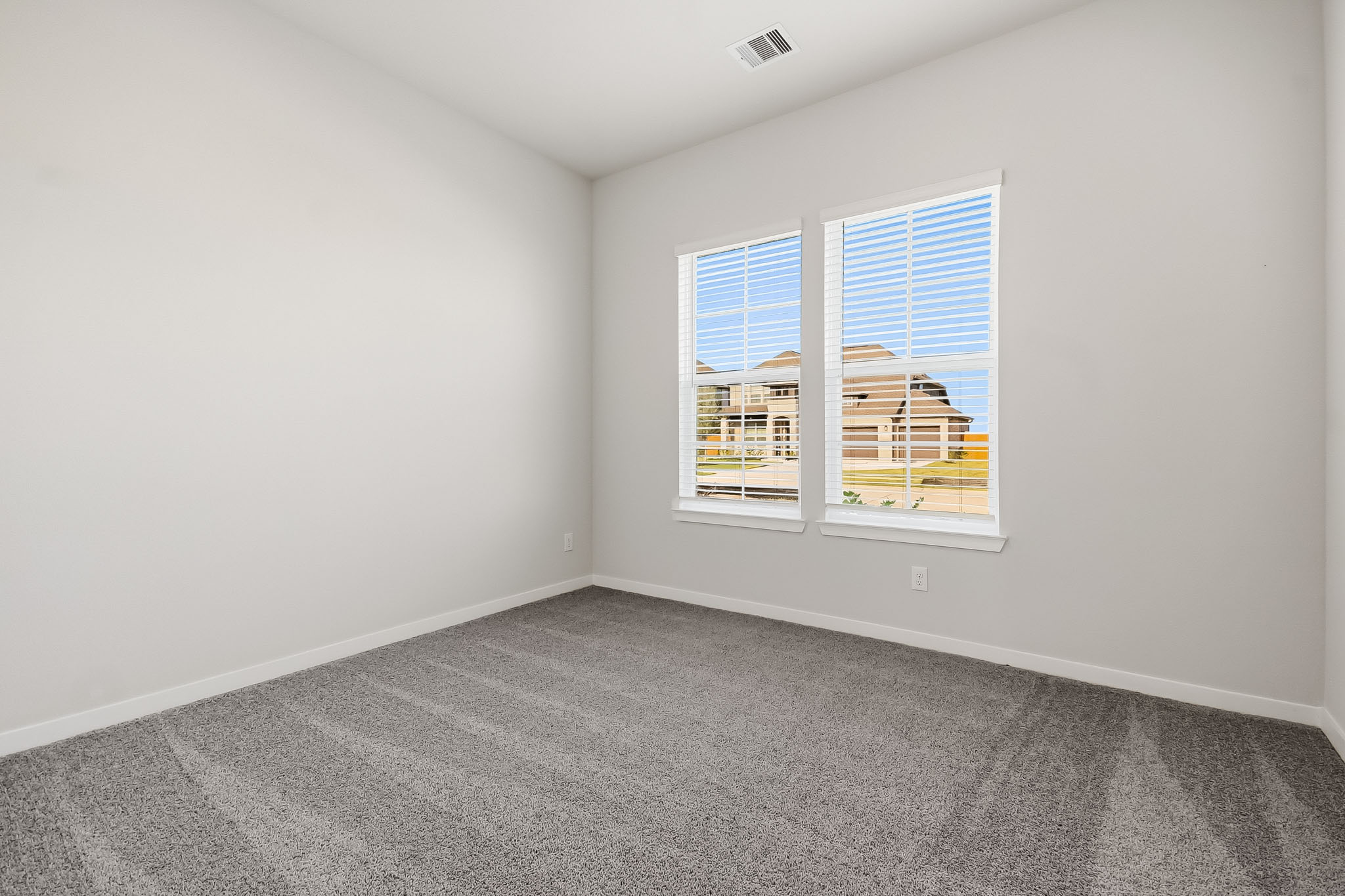A room with a window and a carpet.
