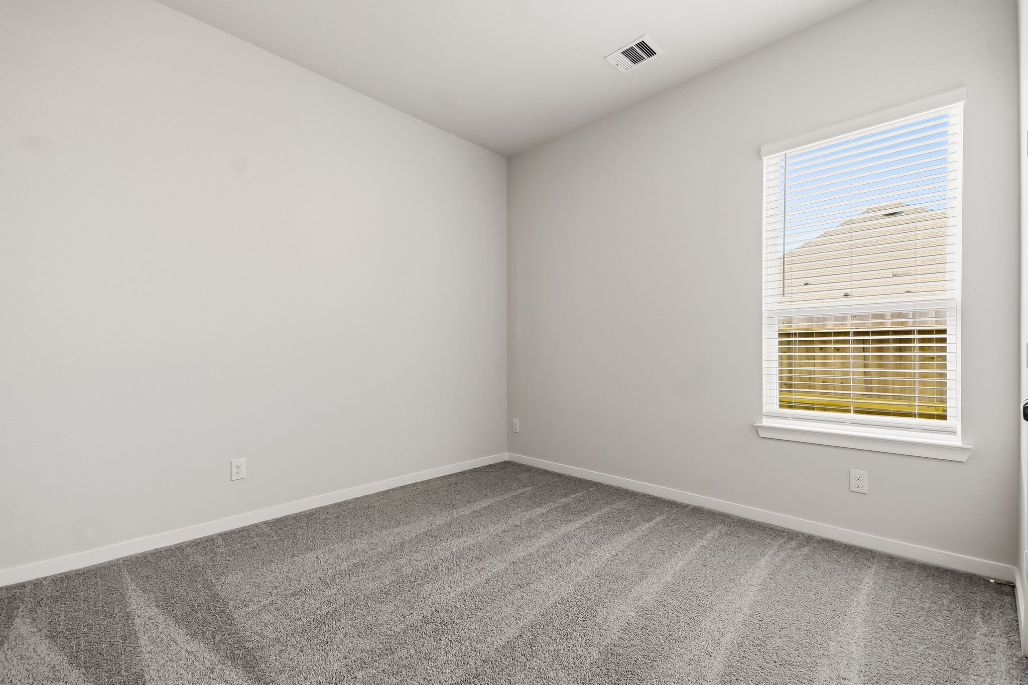 A room with a window and a carpet.