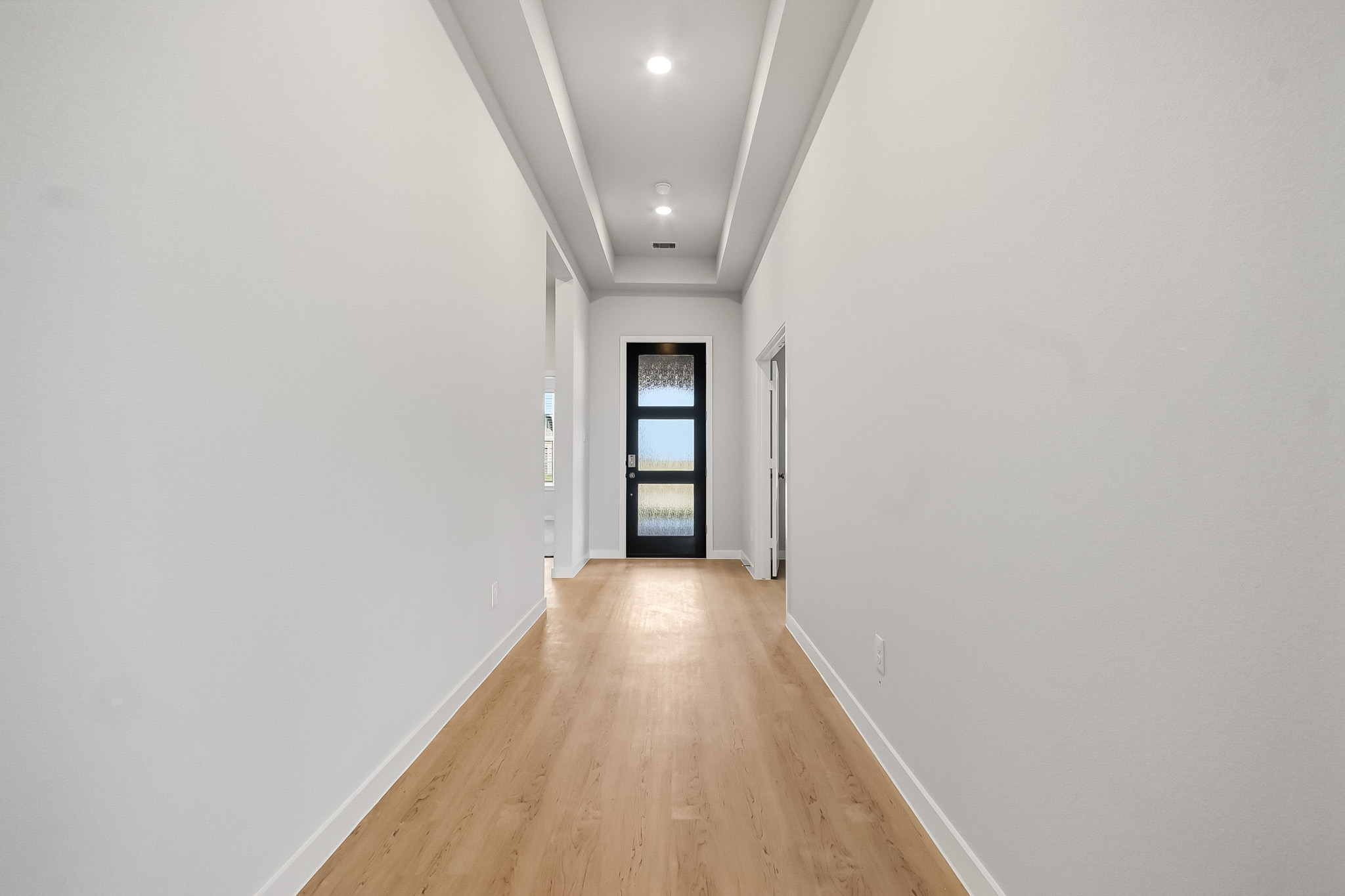 A hallway with a wood floor.