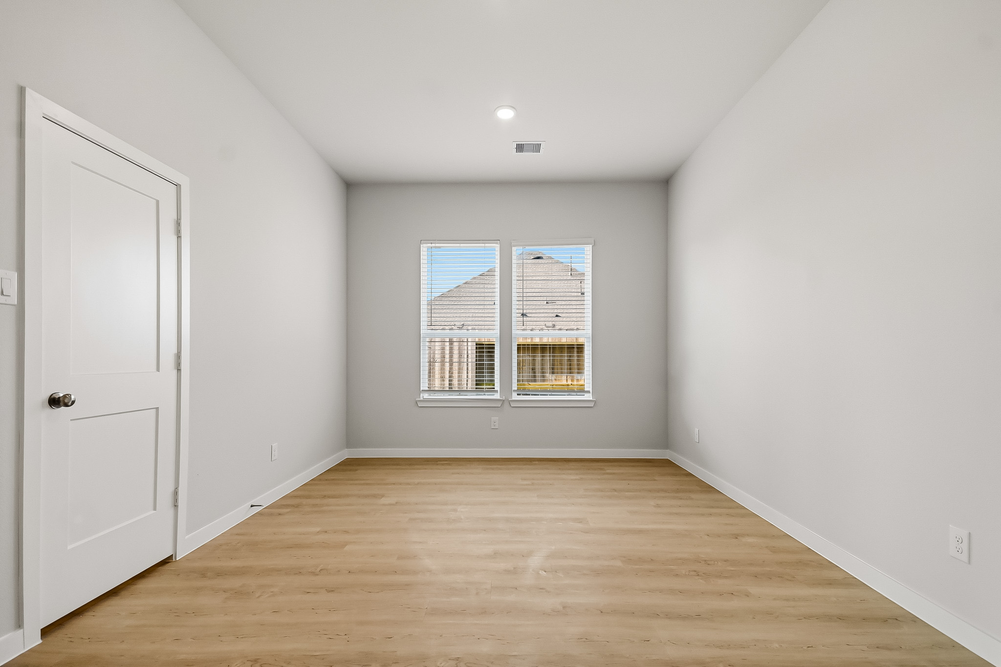 A room with a wood floor and white walls.