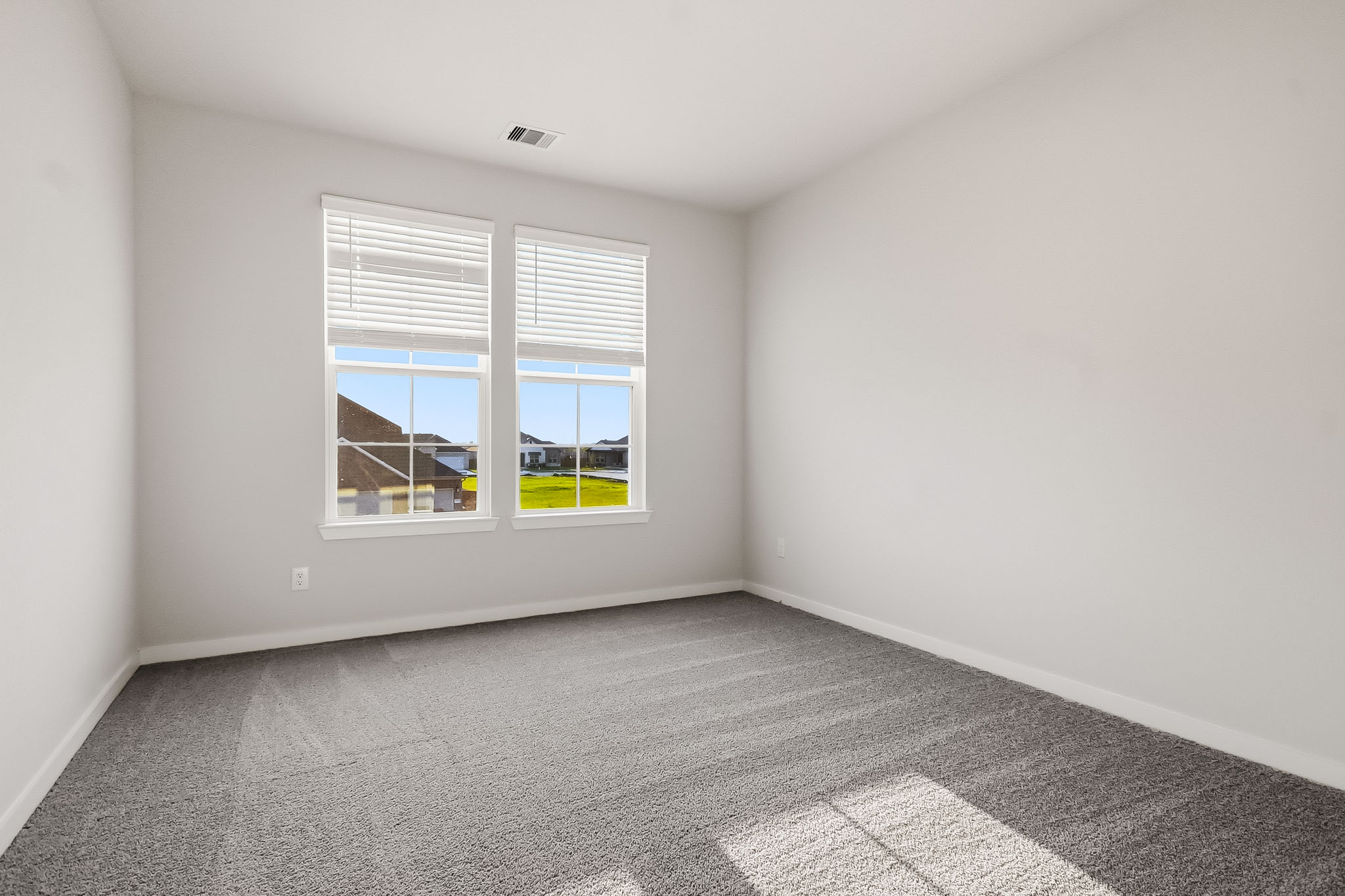 A room with a window and a white wall with a view of the water.