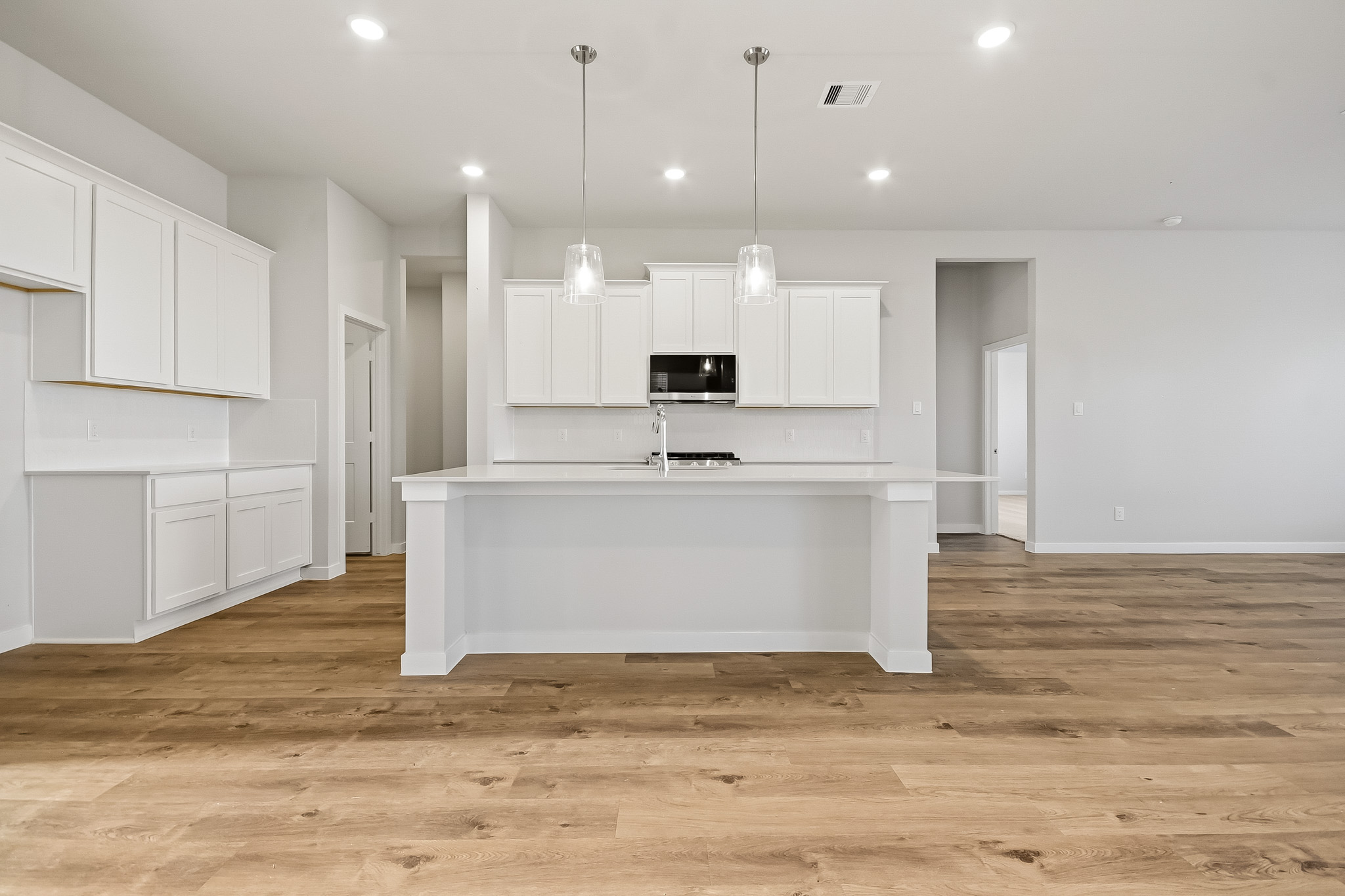A kitchen with white cabinets.