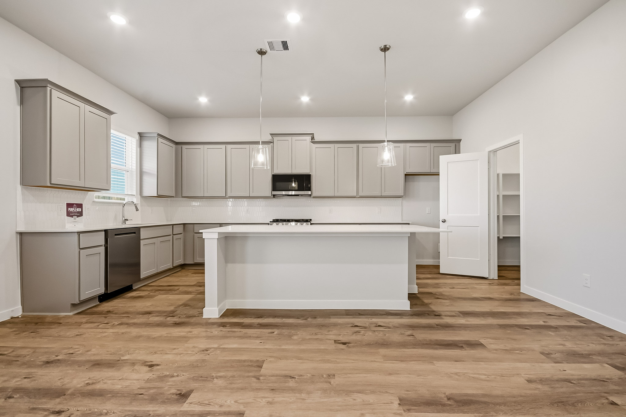 A kitchen with white cabinets.