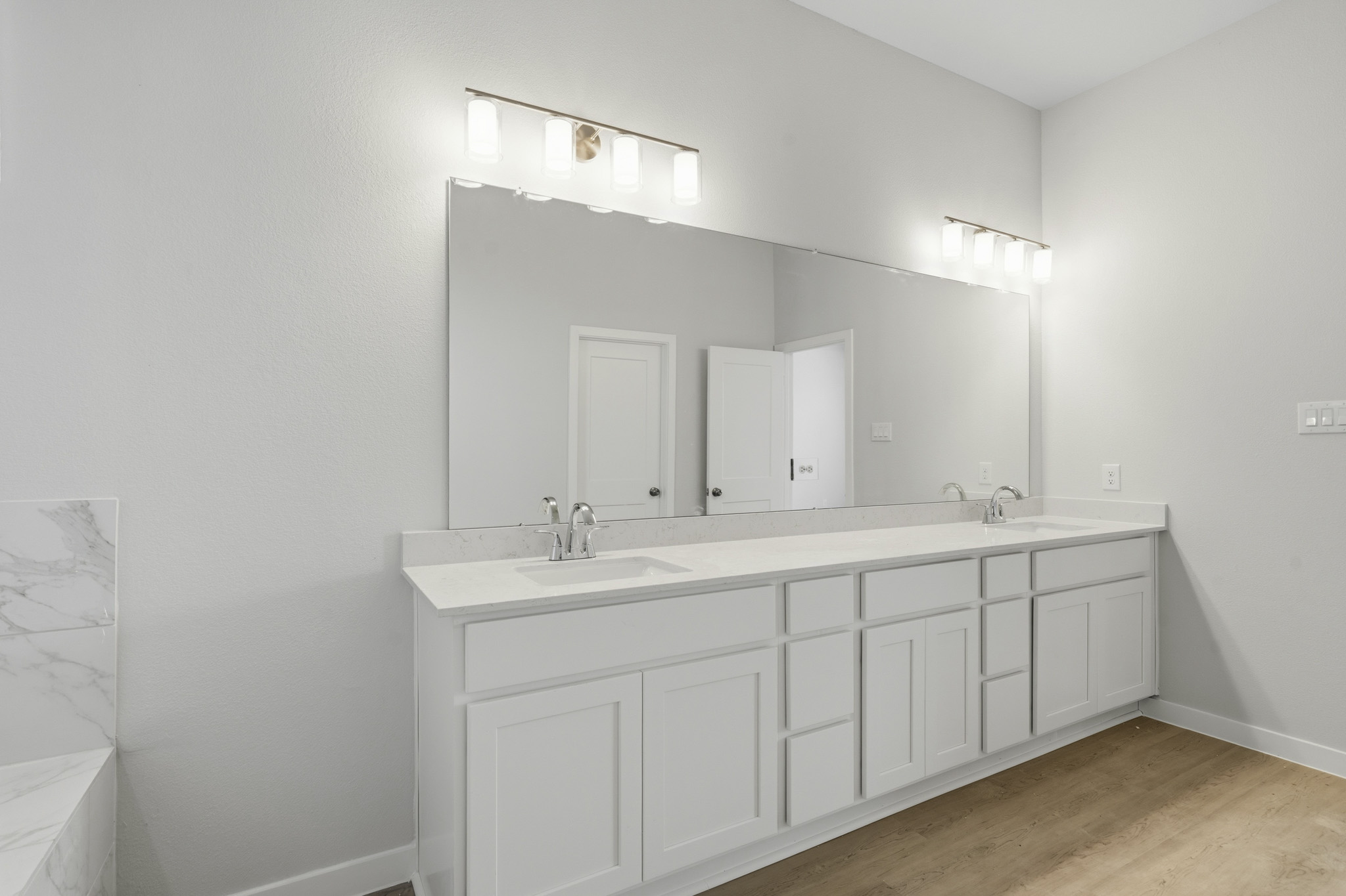 A bathroom with white cabinets.