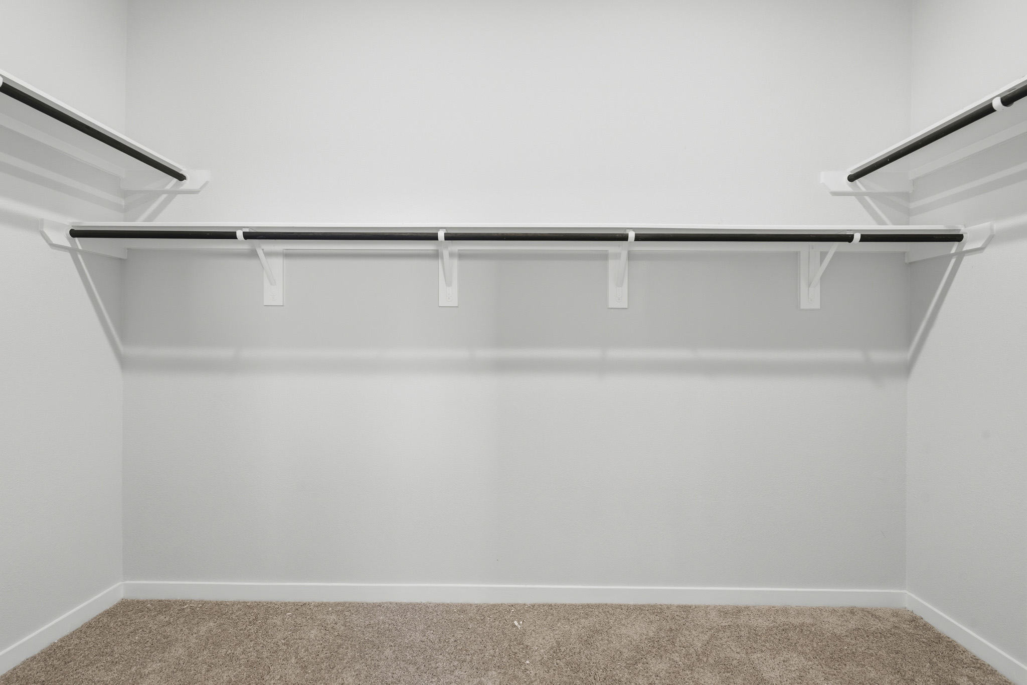 A white wall with a metal bar.