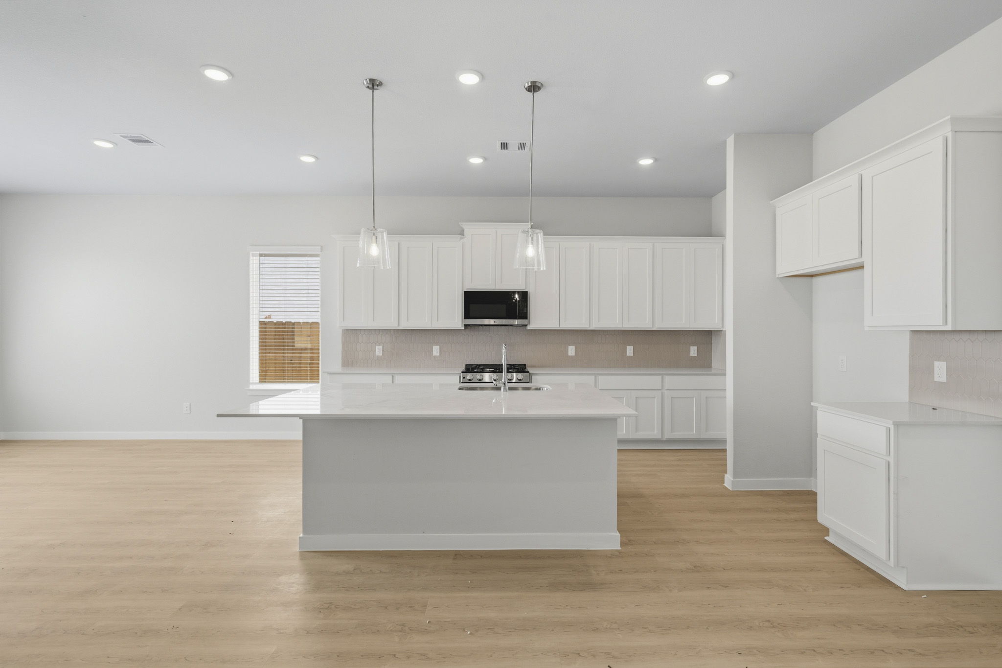 A kitchen with white cabinets.