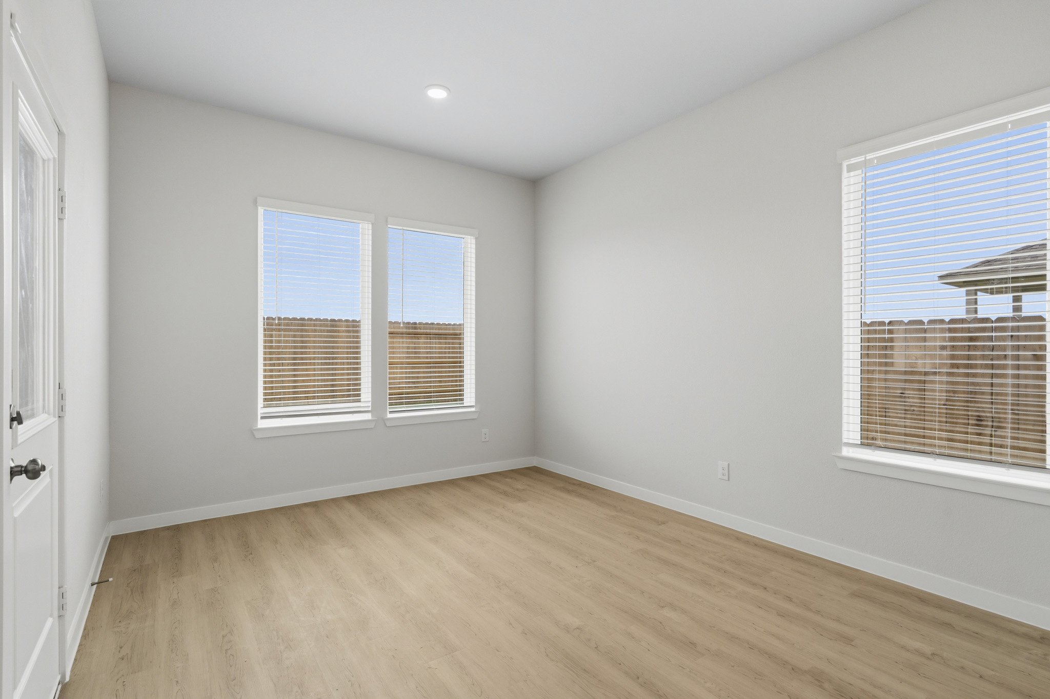 A room with a wood floor and windows.