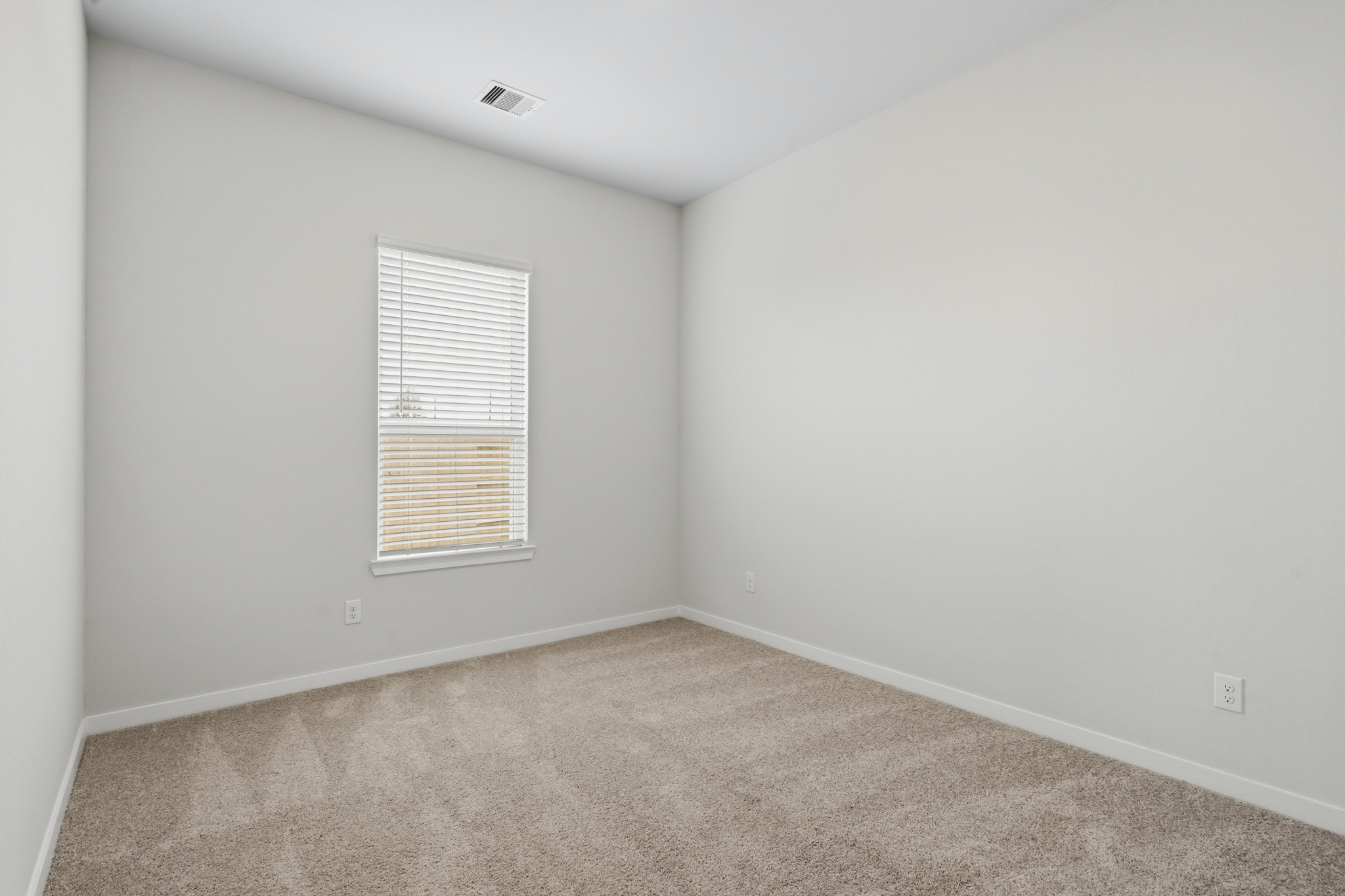 A room with a window and carpet.