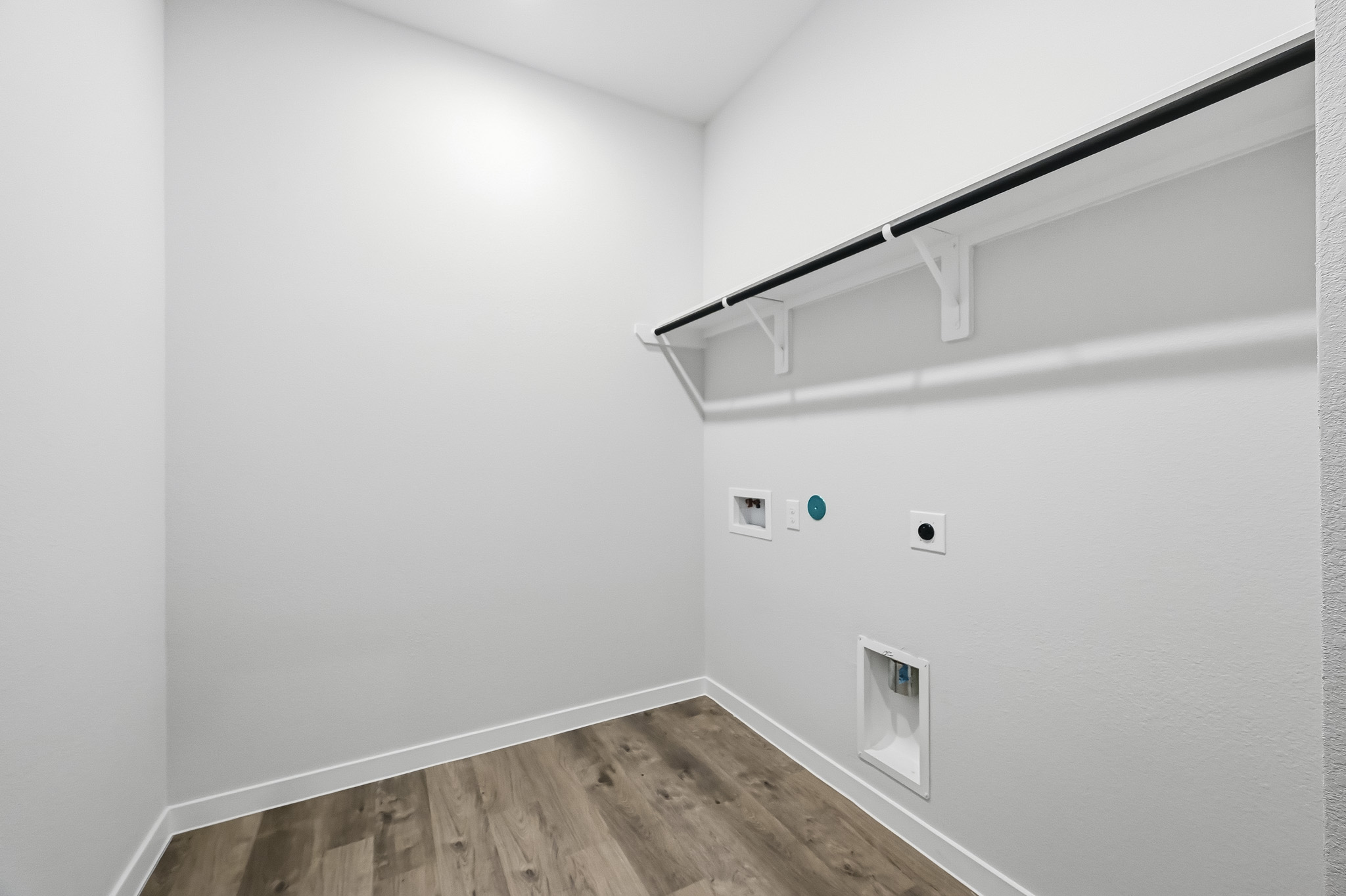 A white wall with a wood floor.