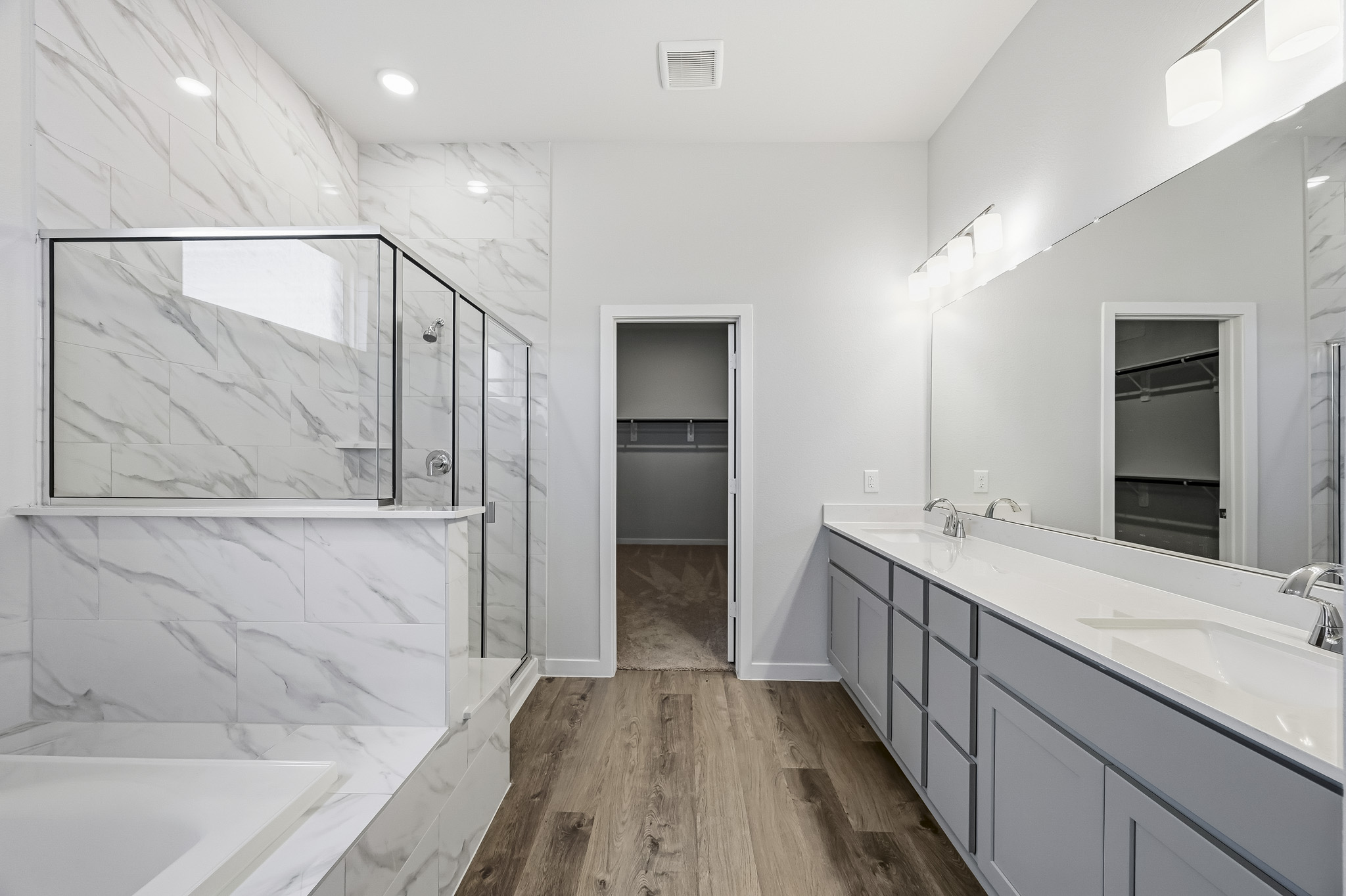 A bathroom with a tub sink and a mirror.