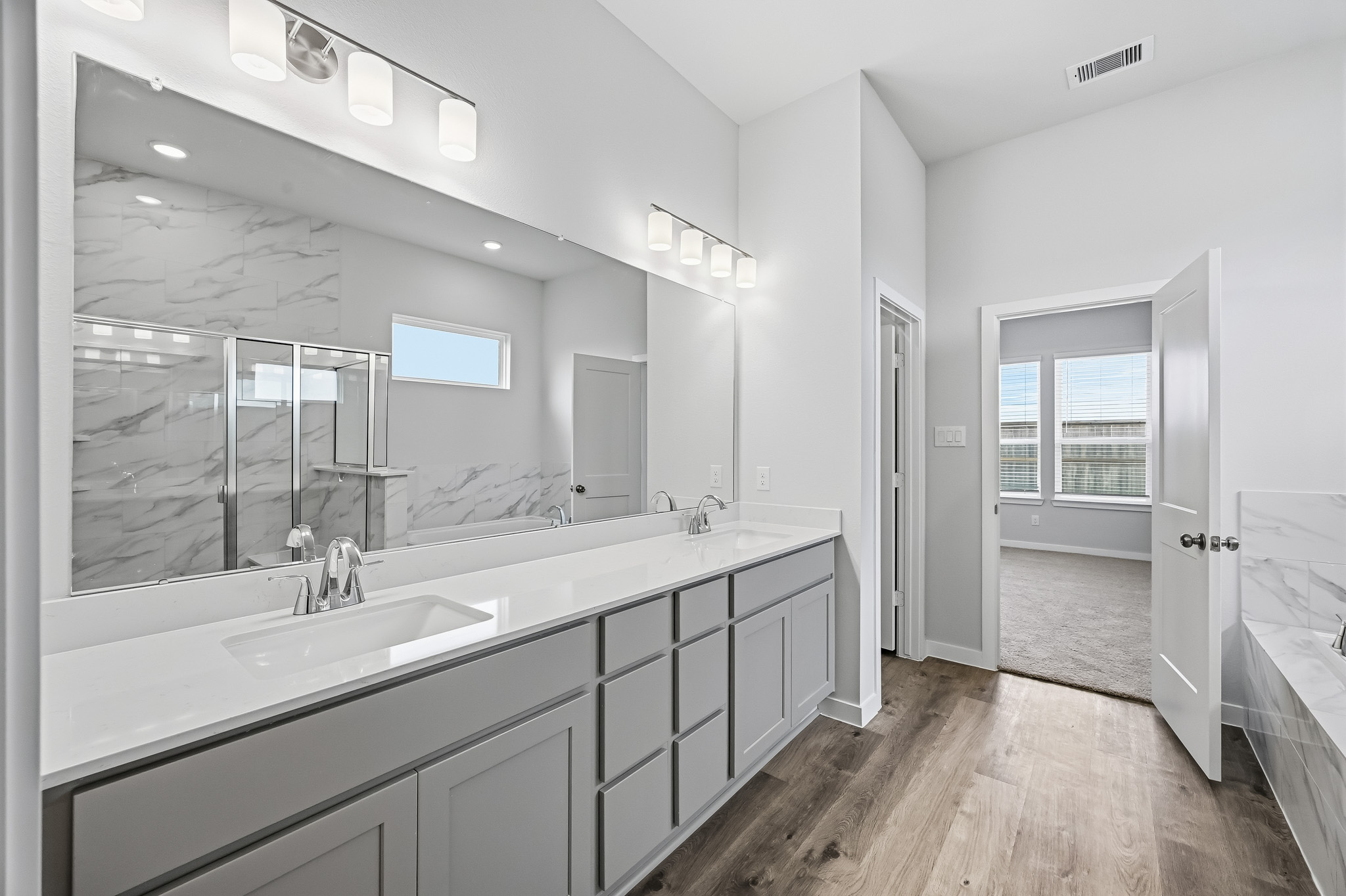 A bathroom with a large mirror.