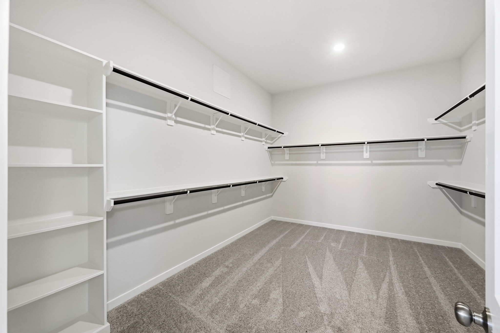 A white room with shelves.