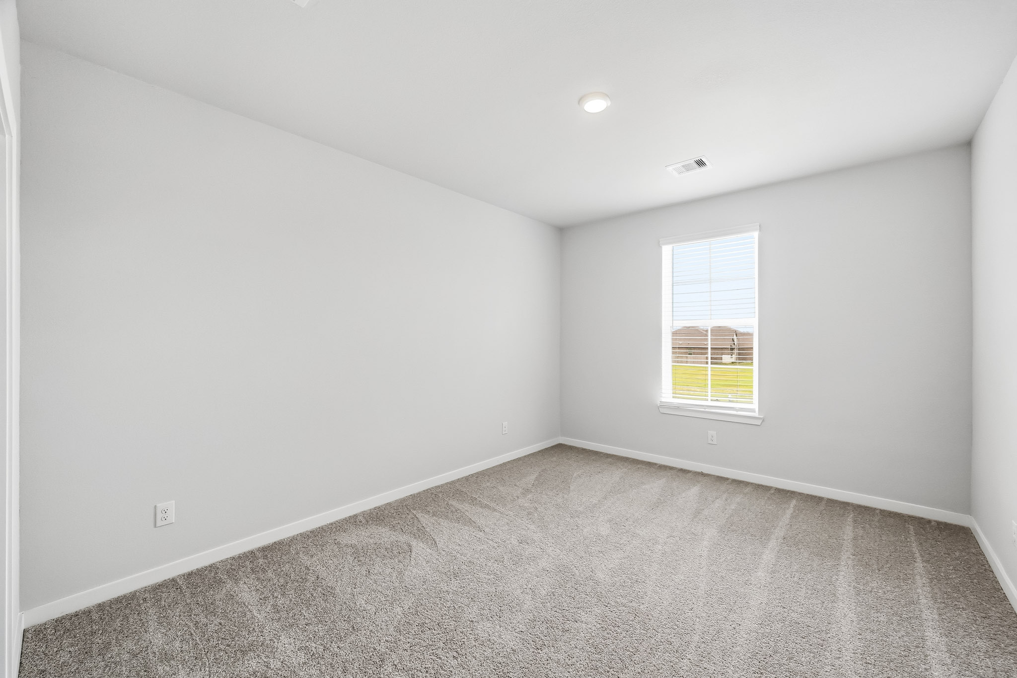 A room with a window and a carpet.