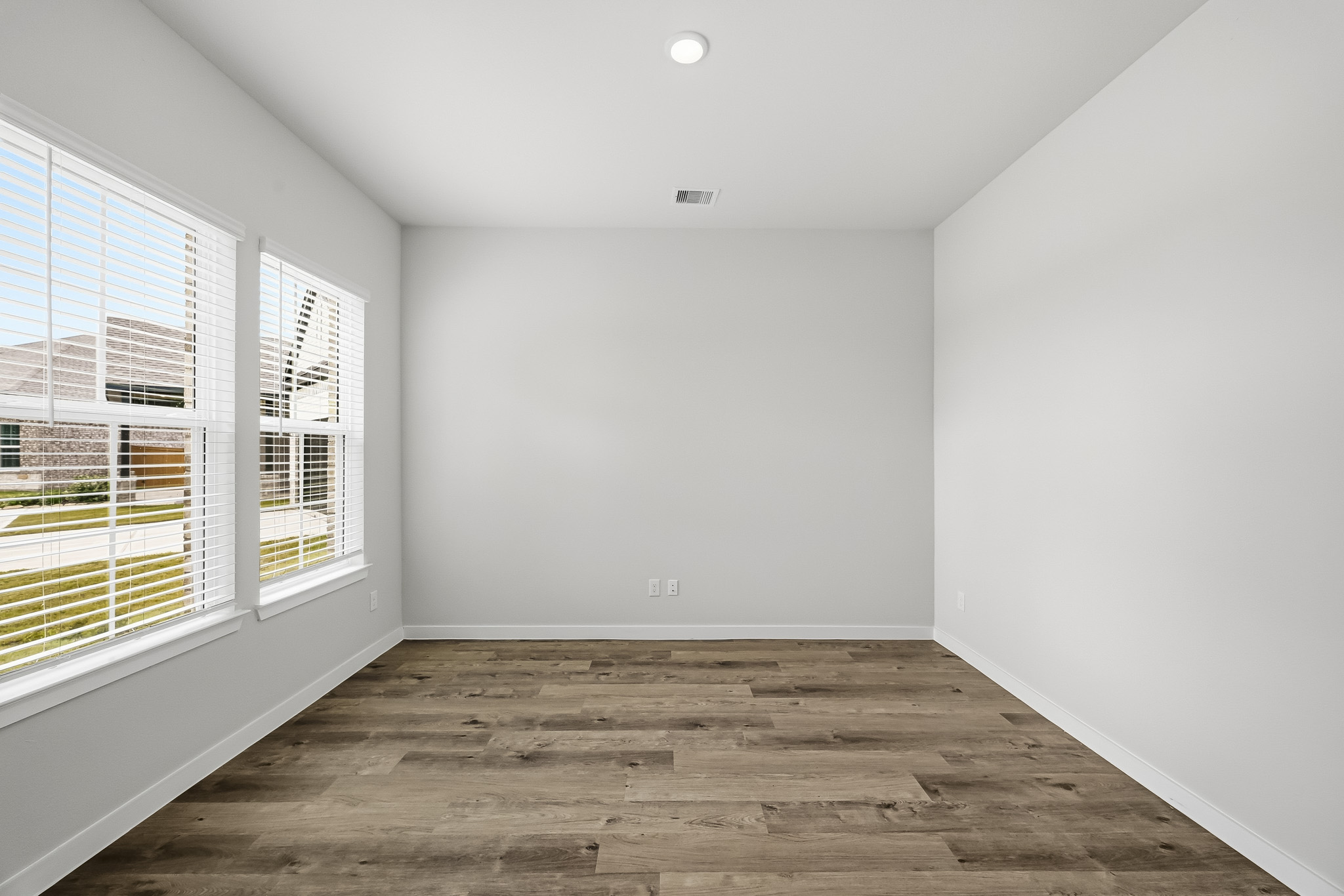 A room with a wood floor and windows.