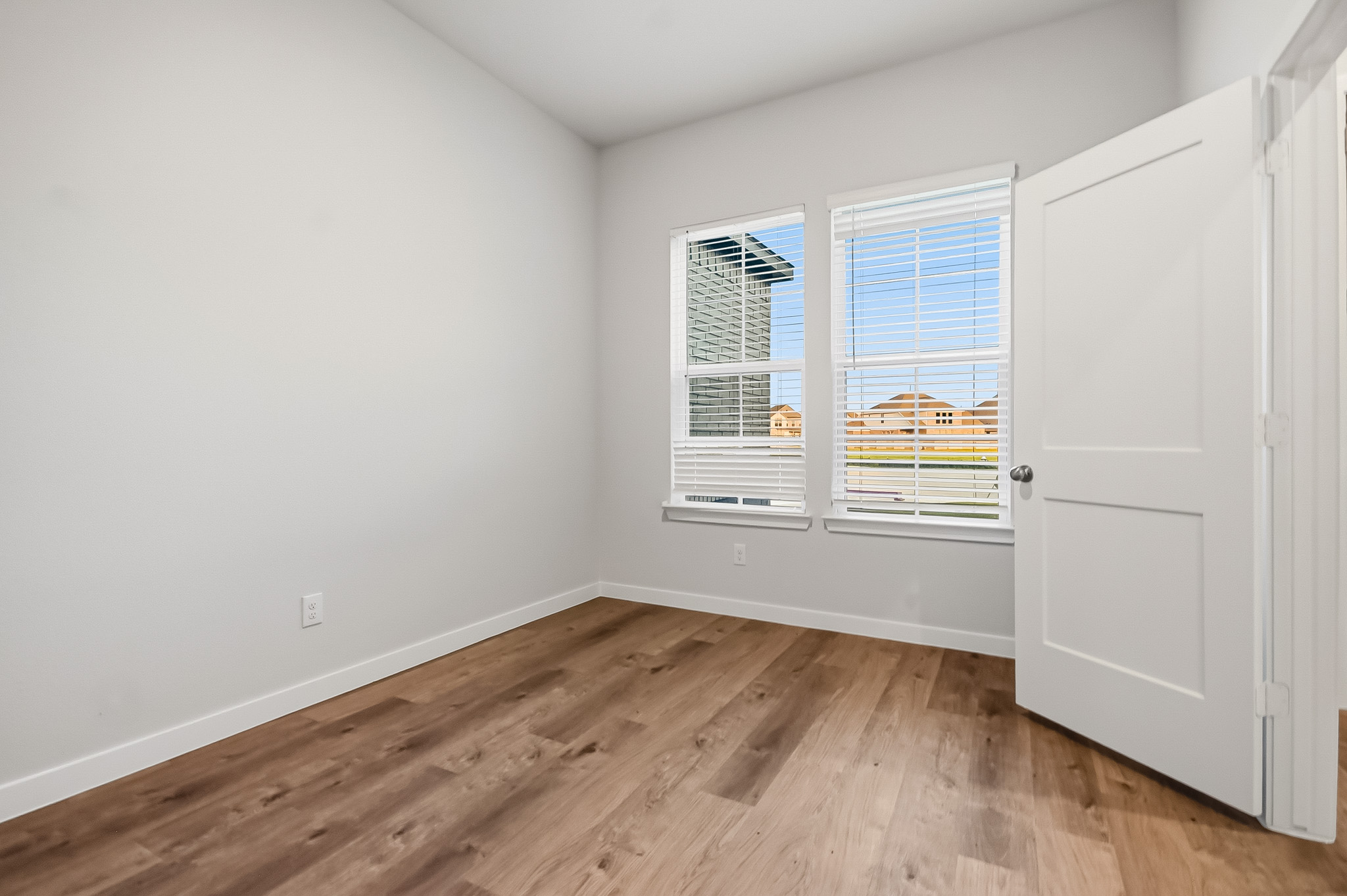 A room with a wood floor and white walls.