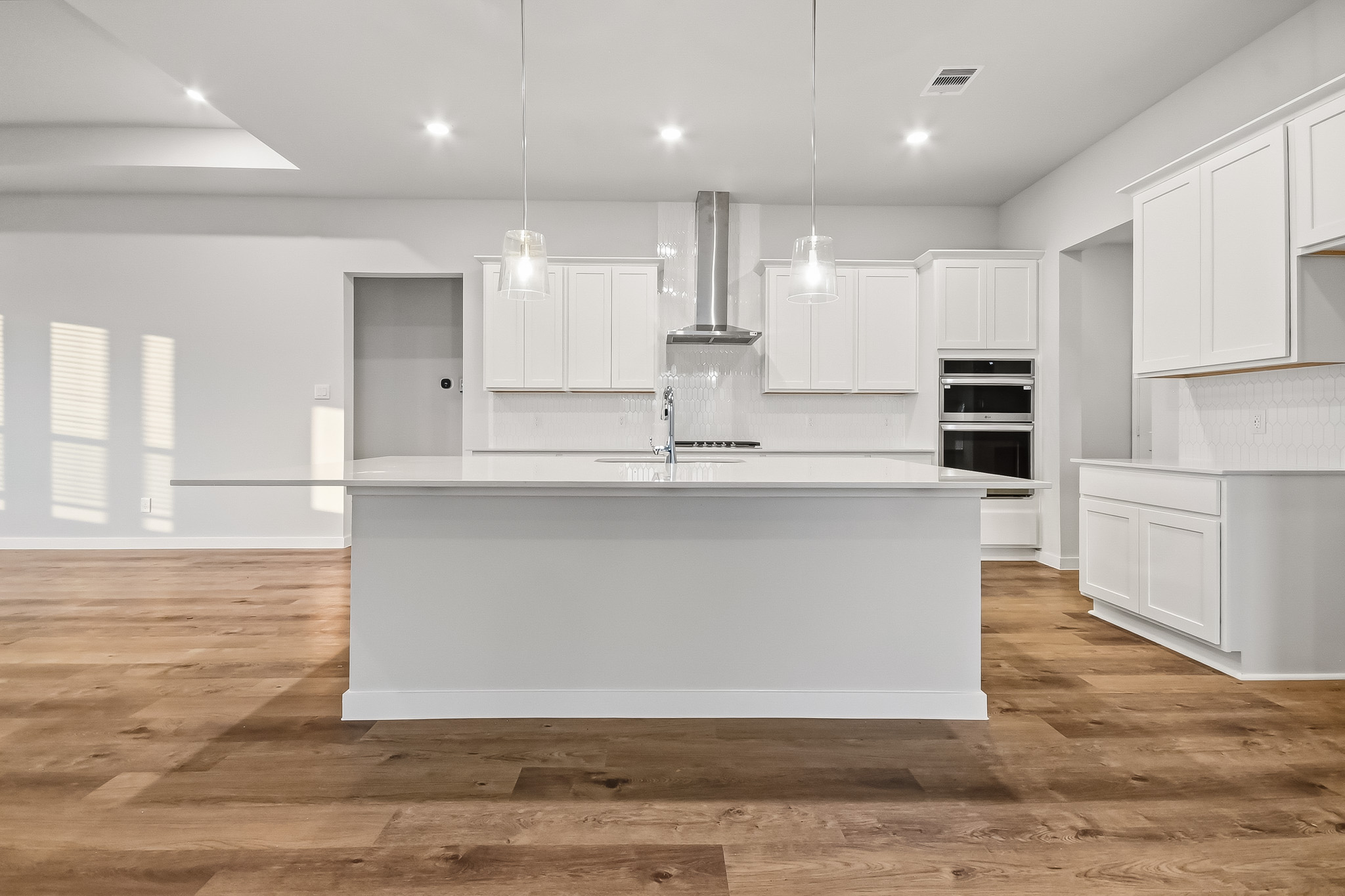 A kitchen with white cabinets.