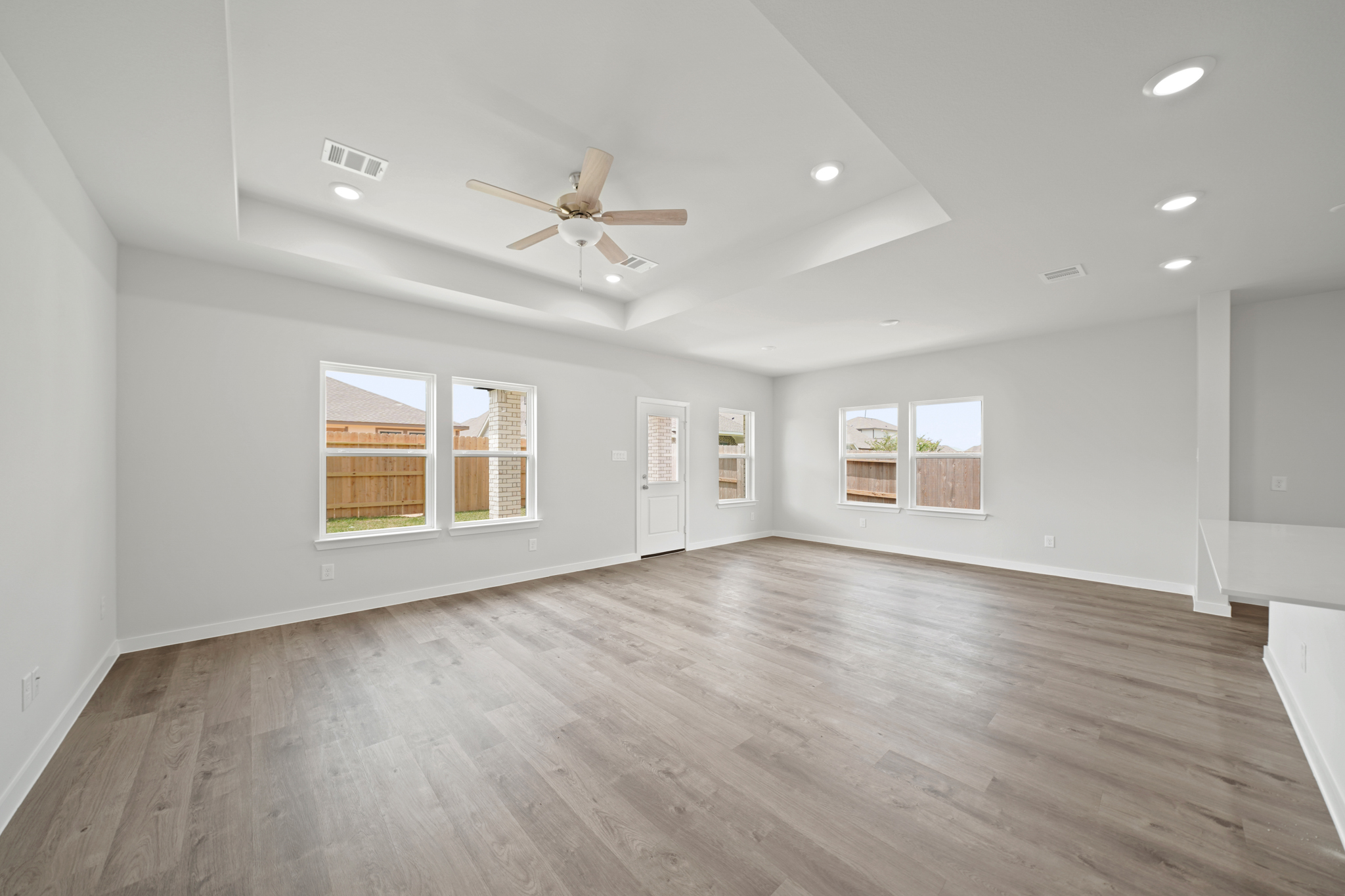 A room with a wood floor and a ceiling fan.