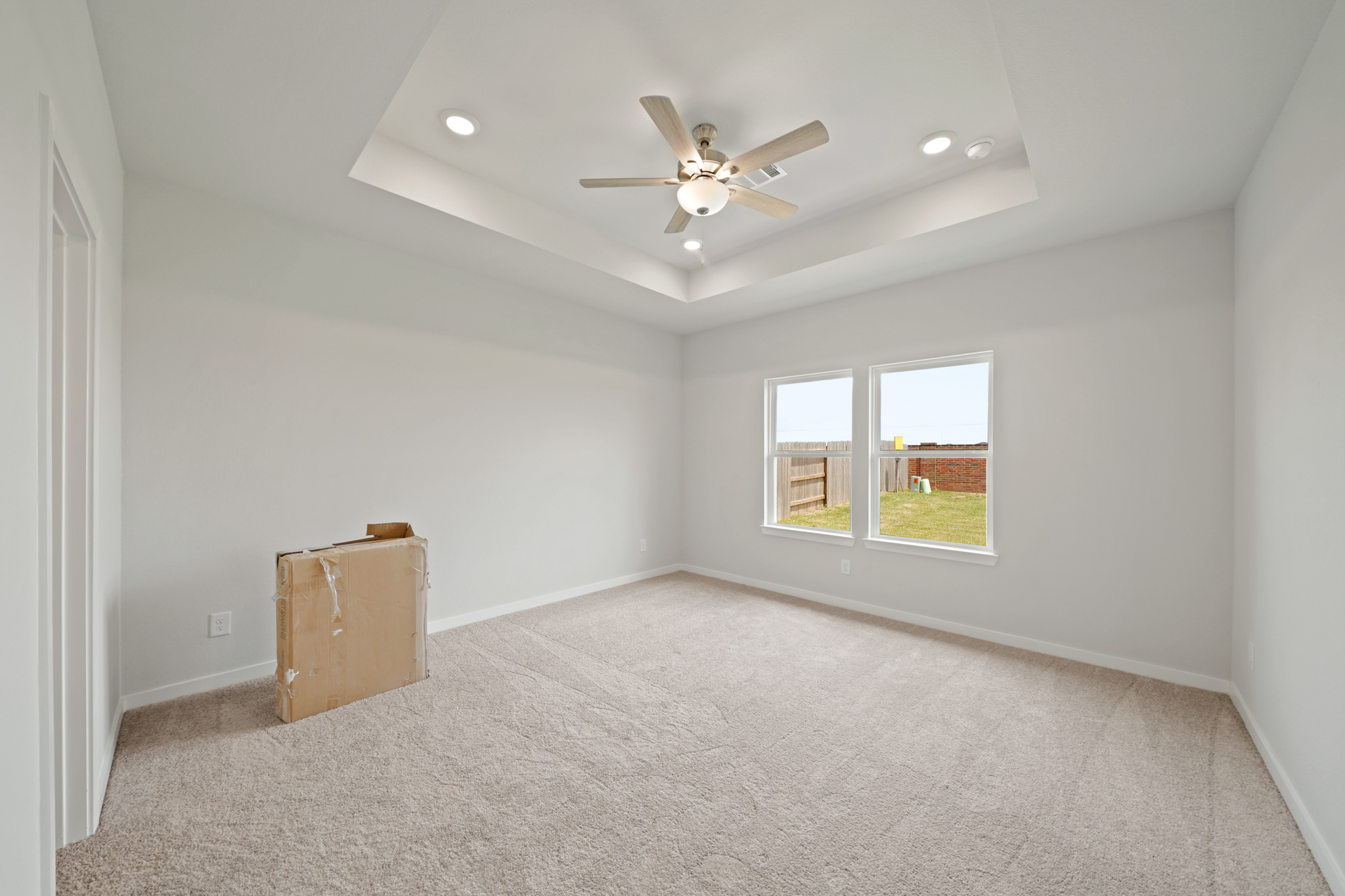 A room with a ceiling fan and a suitcase.