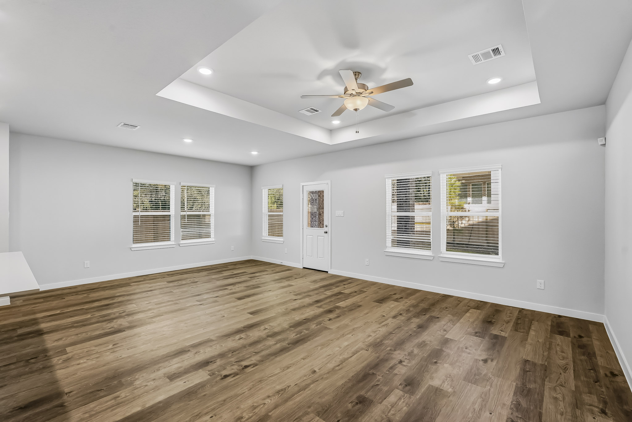 A room with a wood floor and a ceiling fan.