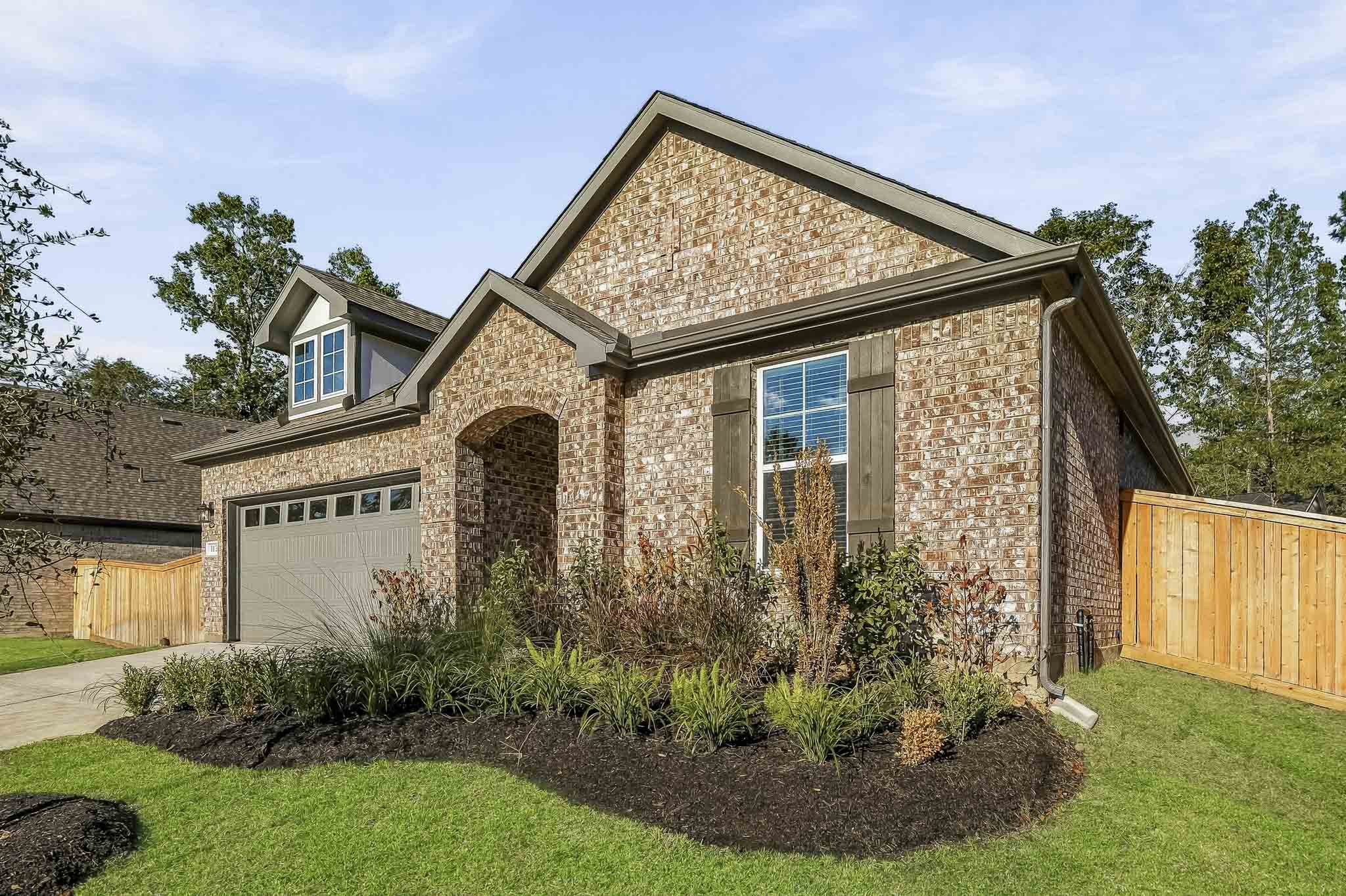 A house with a fence and a yard with a dirt patch.