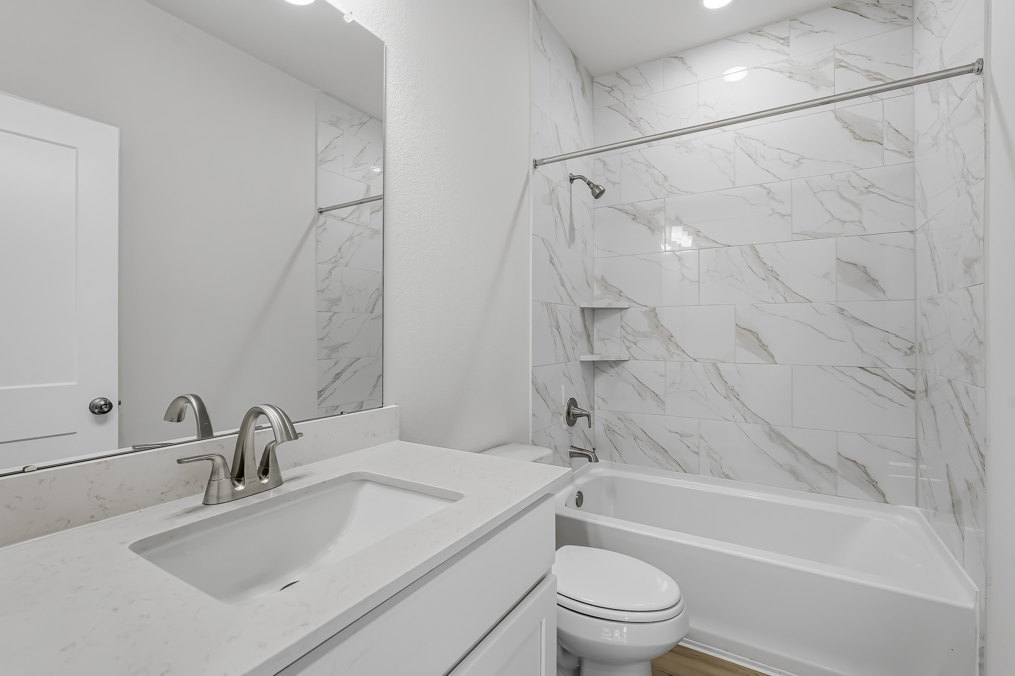 A bathroom with a tub sink and toilet.