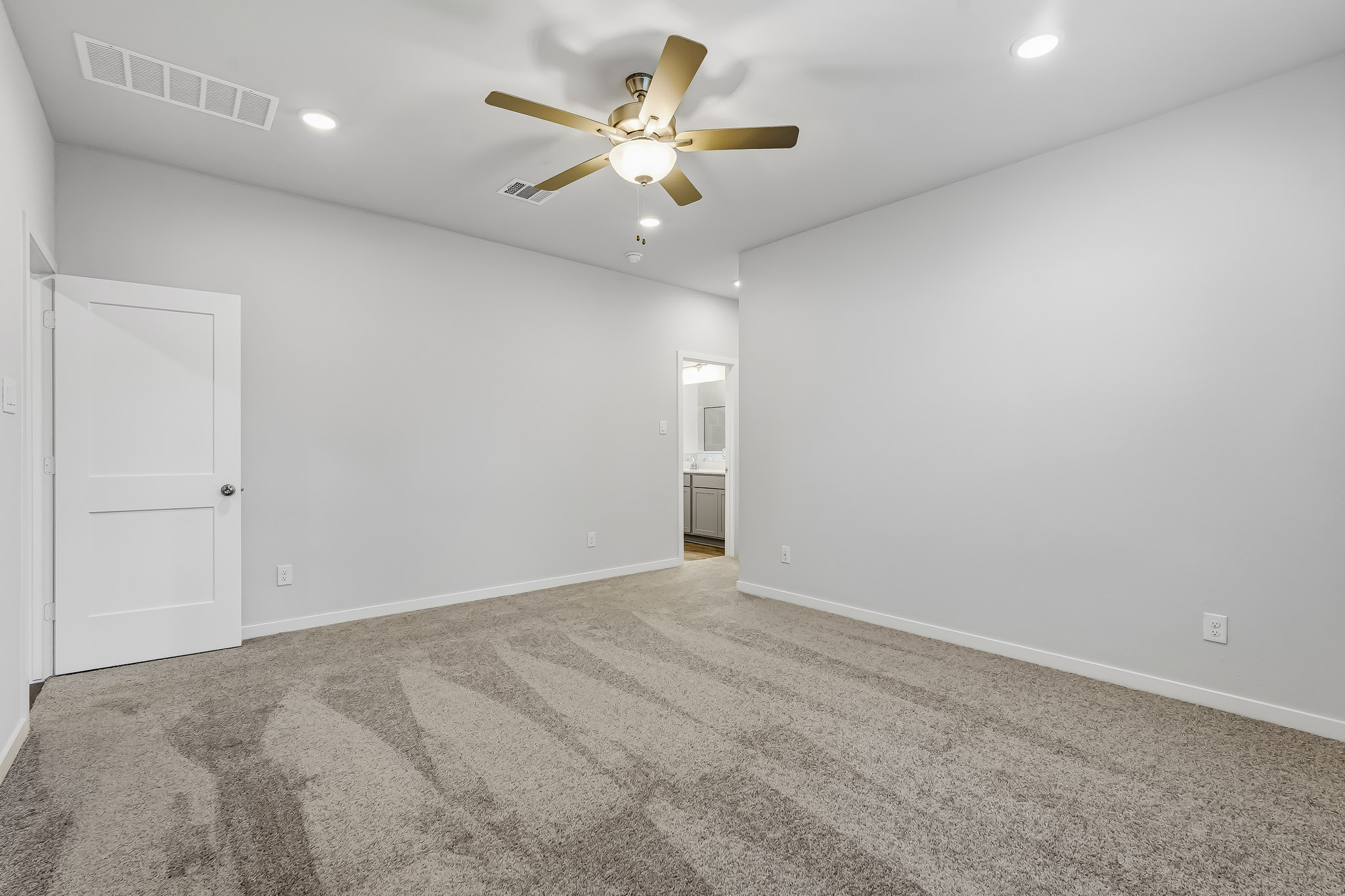 A room with a ceiling fan and a door.