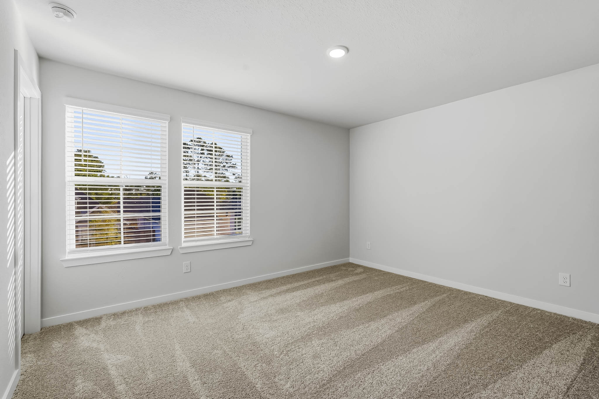 A room with a carpet and a window.