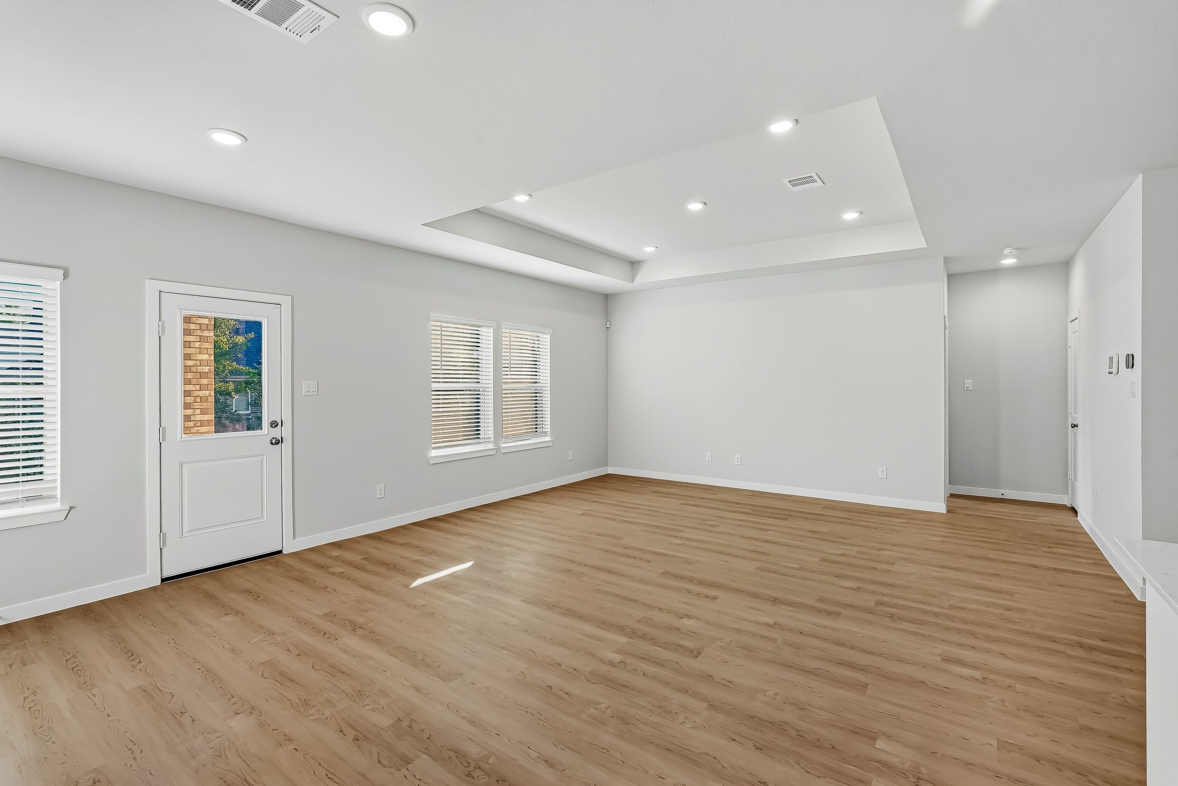 A room with white walls and wood floors.