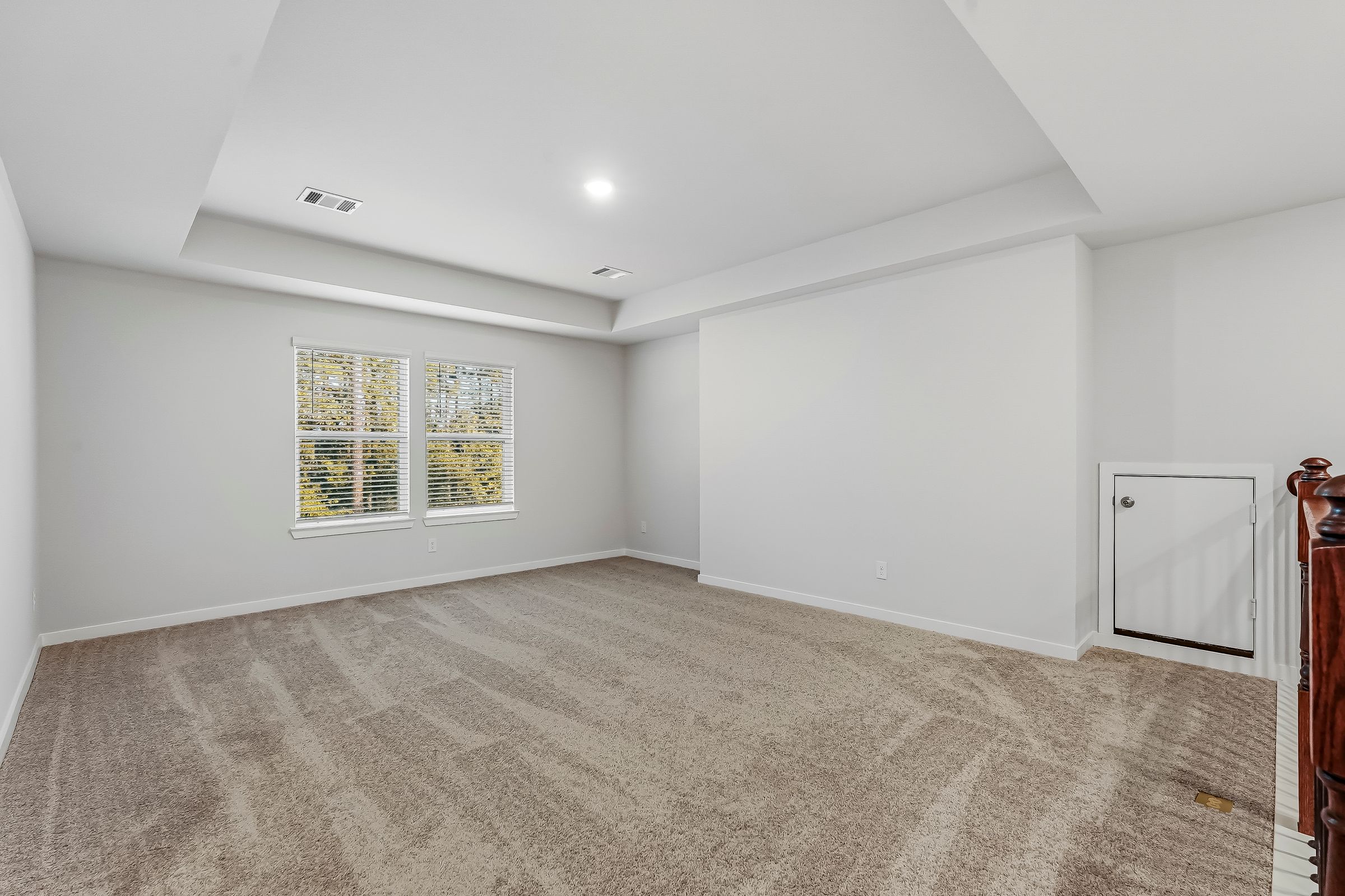A room with a carpet and a window.