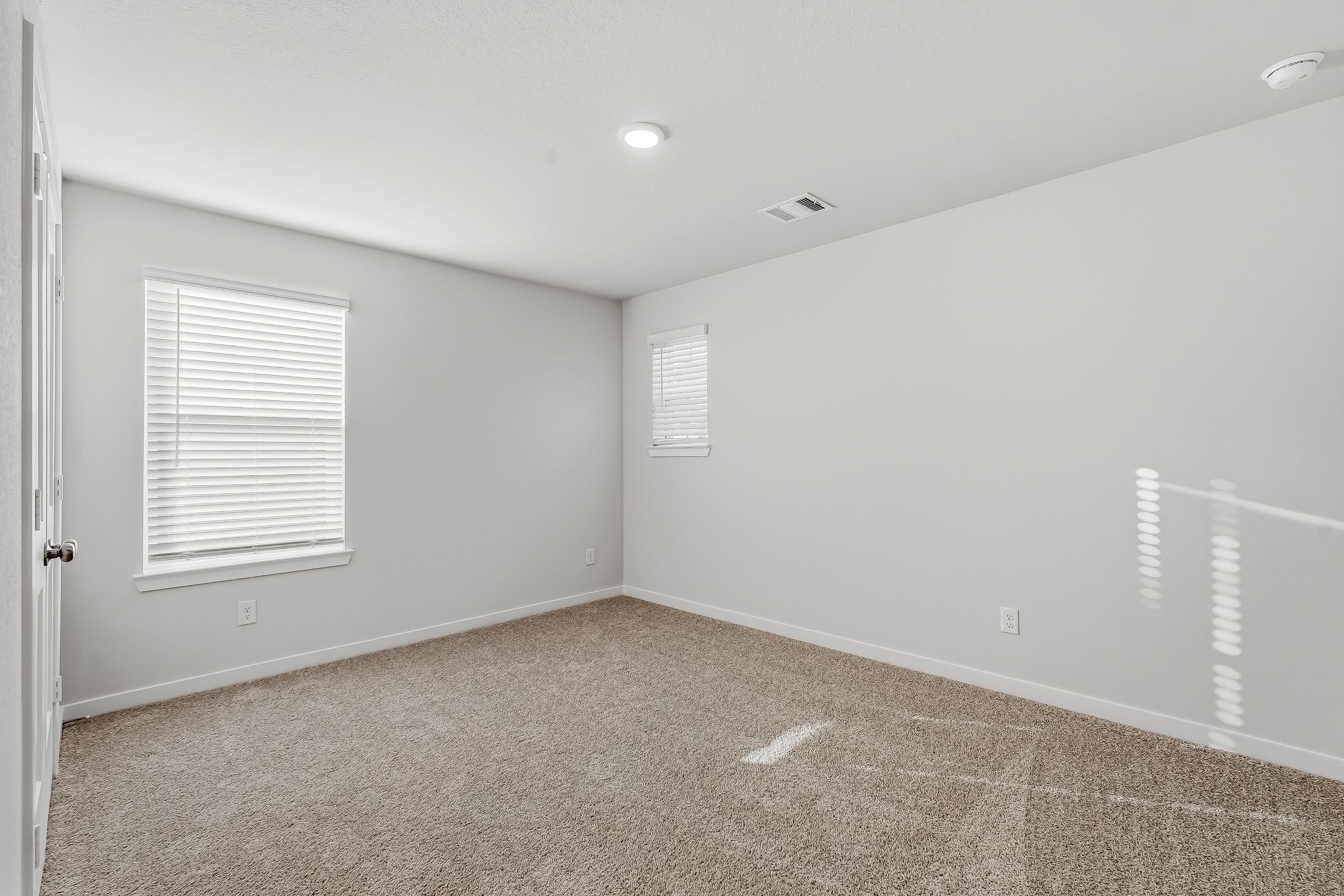 A room with a carpet and a door.