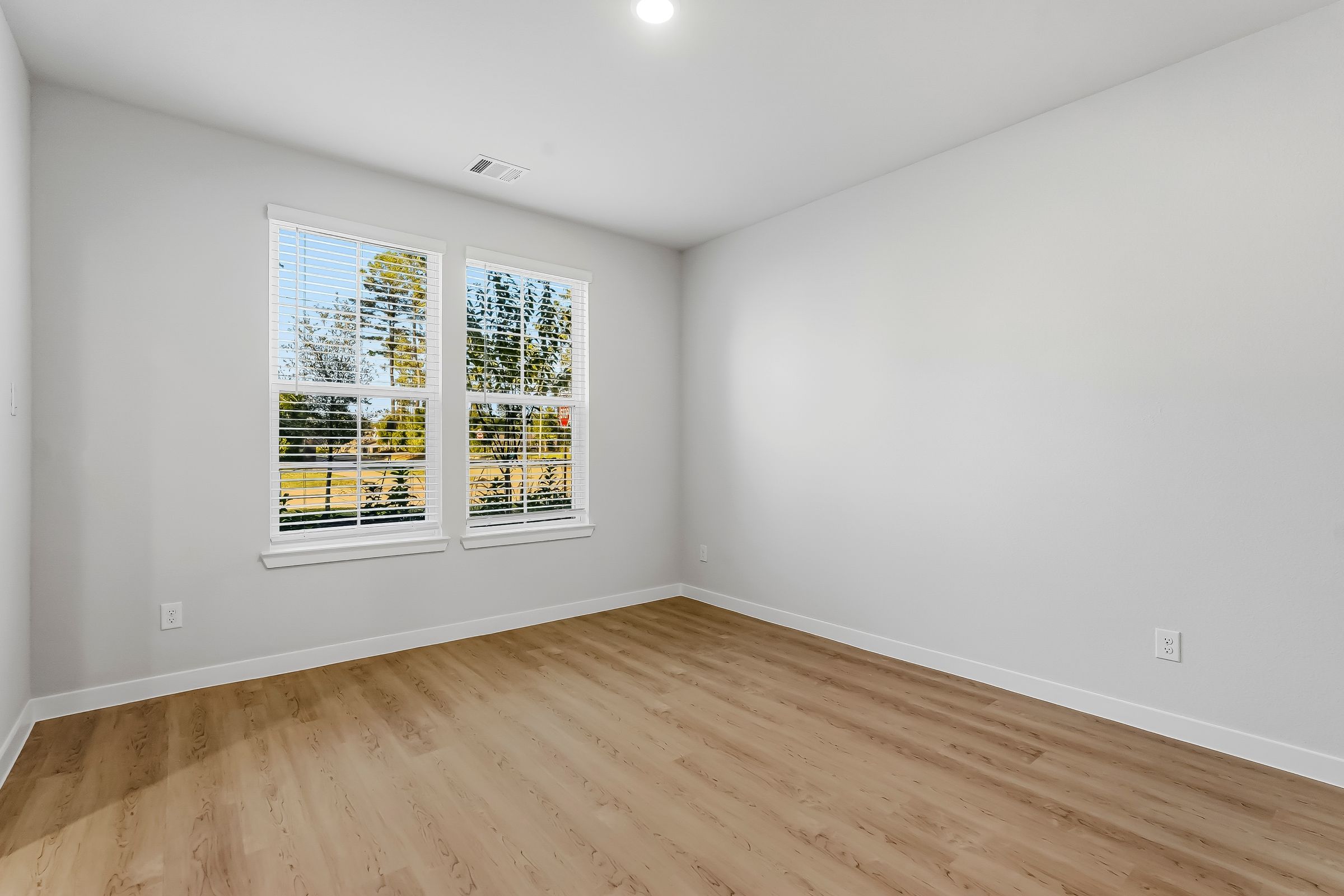 A room with a wood floor and a window with a wood floor.