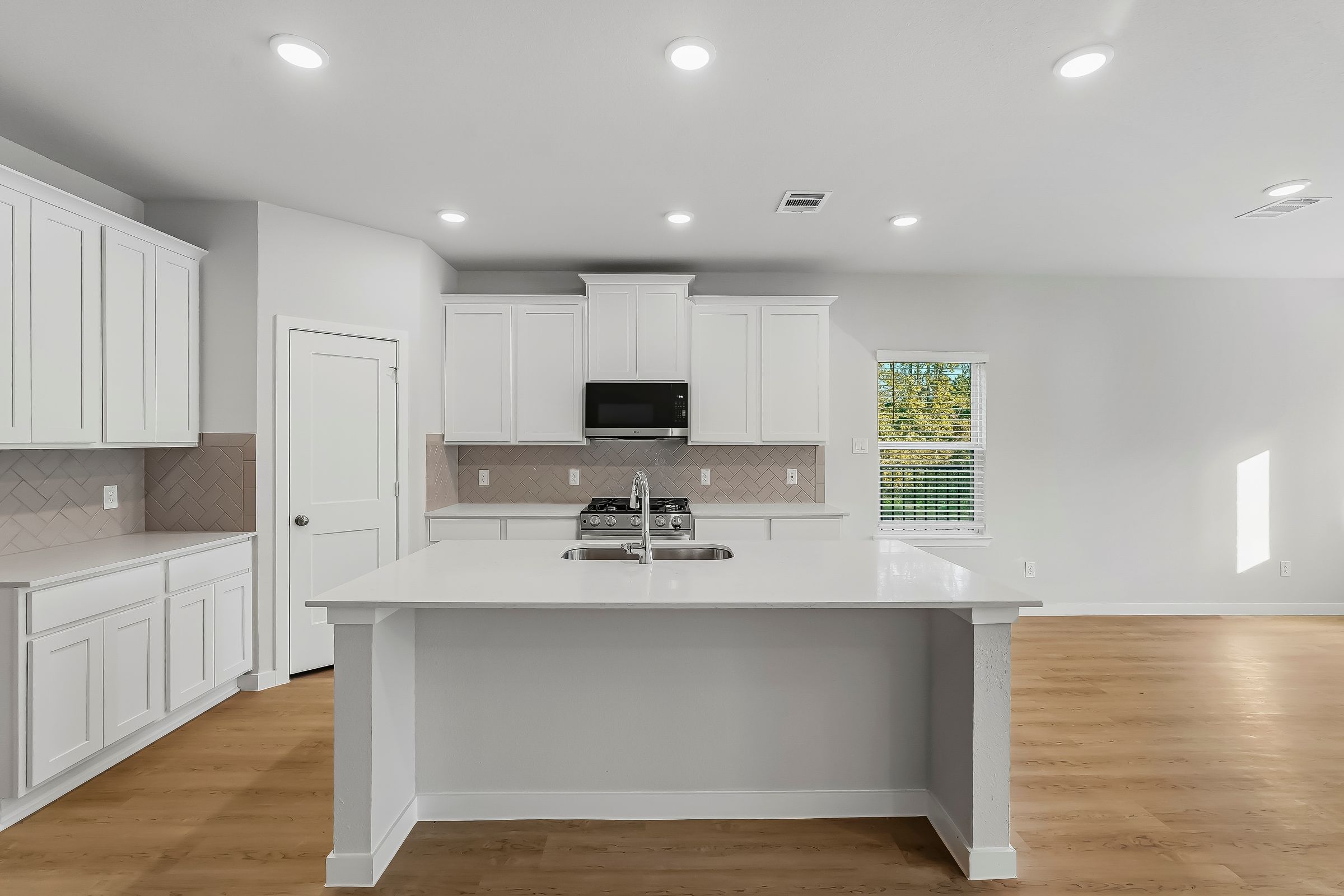 A kitchen with white cabinets.