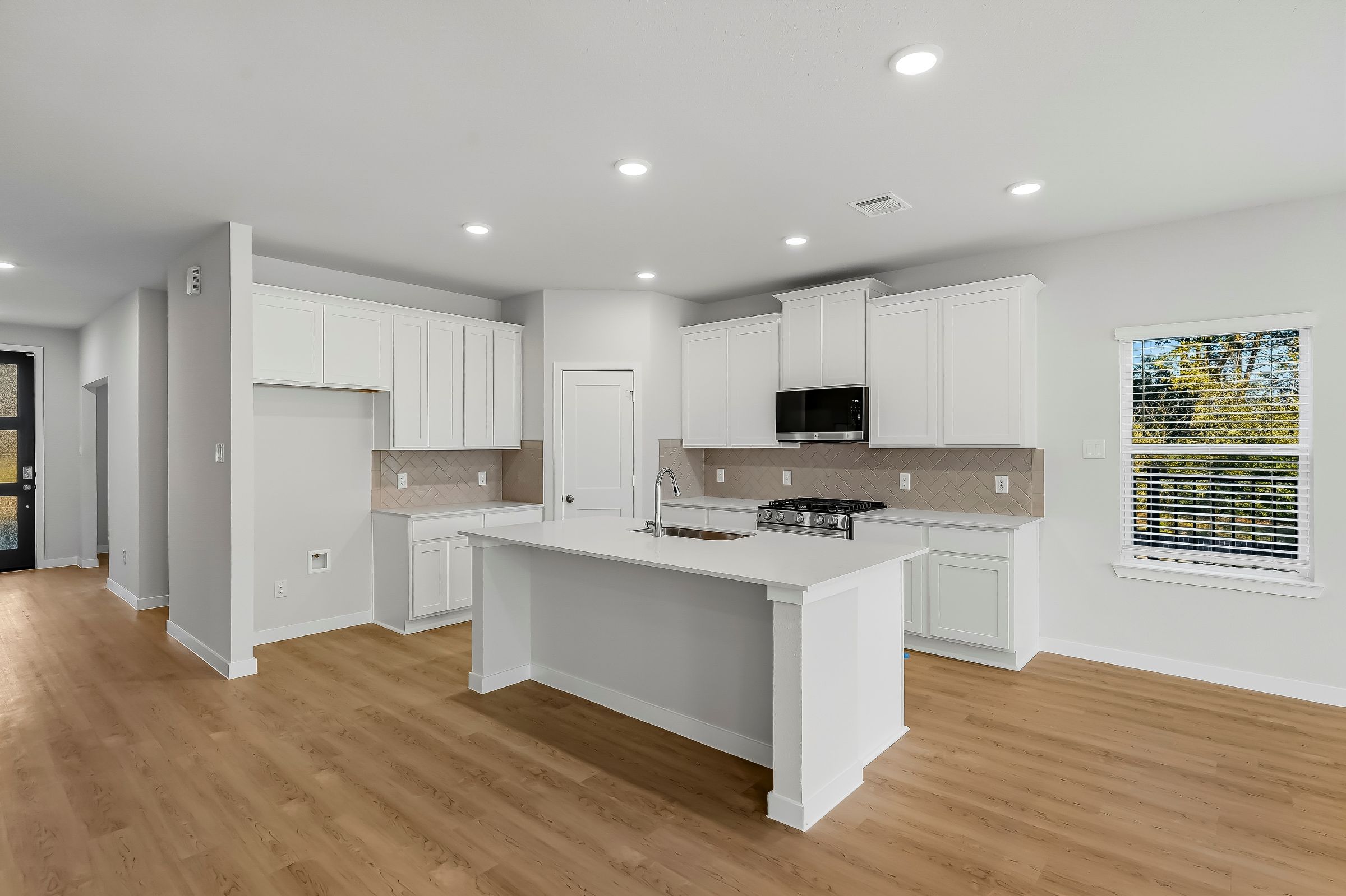 A kitchen with white cabinets.