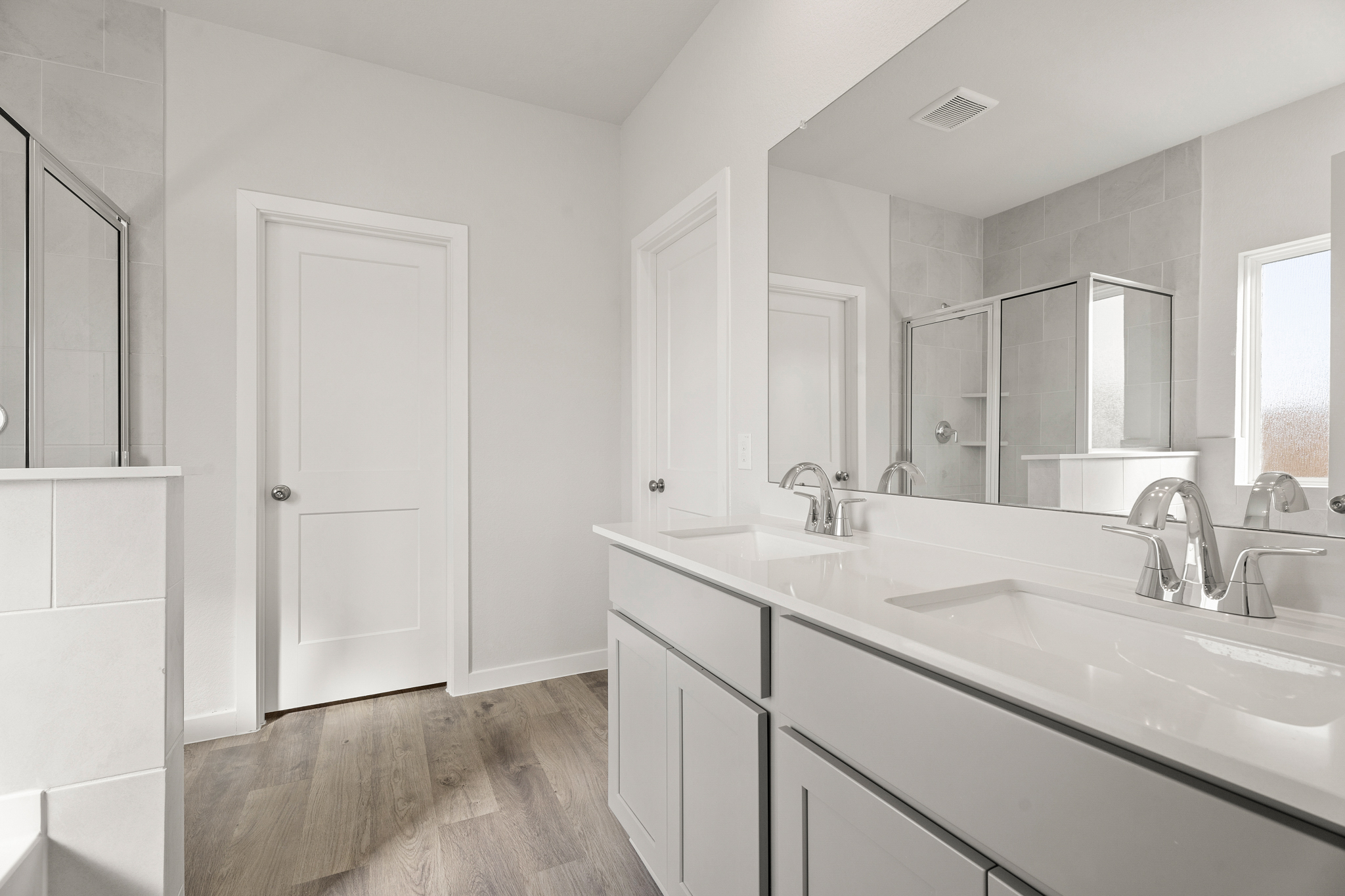 A bathroom with white cabinets.