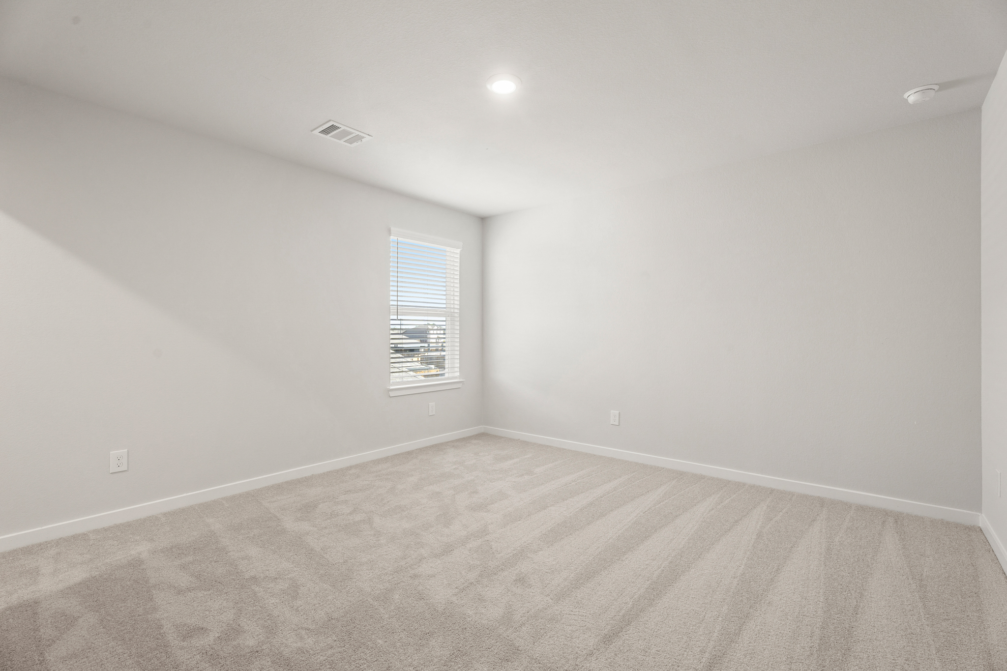 A room with a window and a carpet.