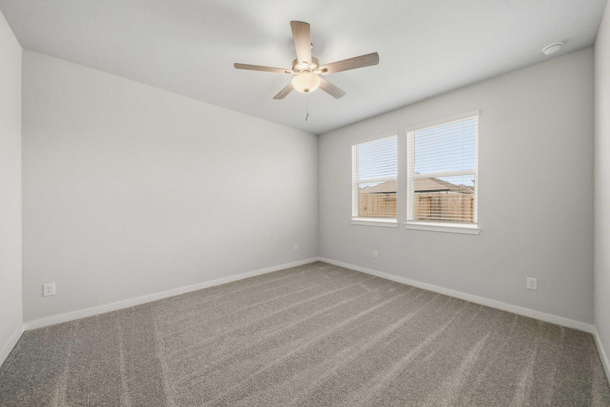 A room with a ceiling fan and a window.