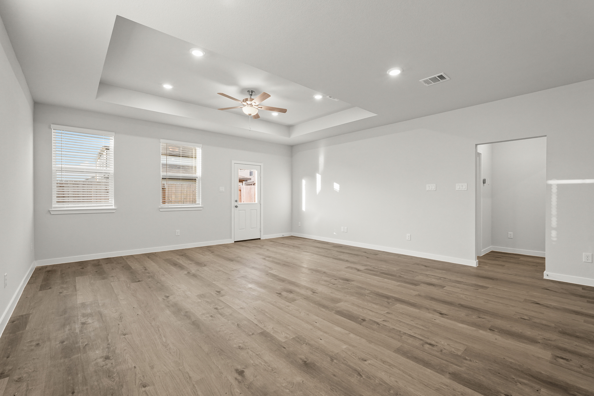 A room with a wood floor and a ceiling fan.