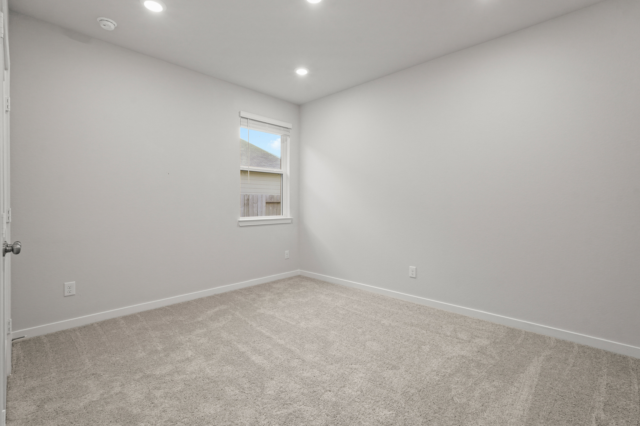 A room with a window and a carpet.