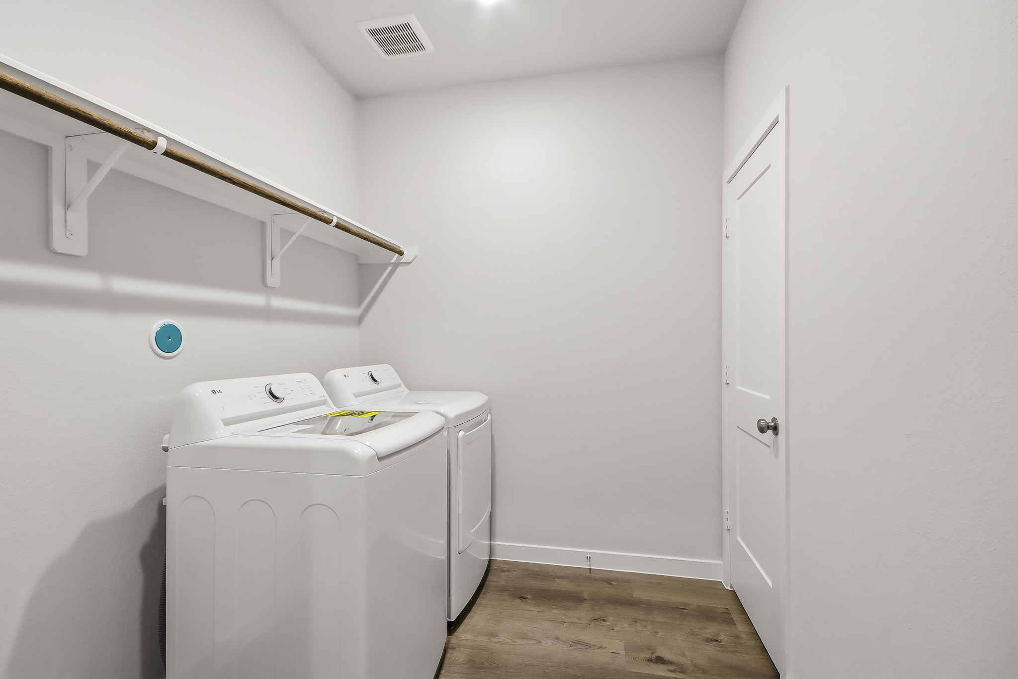 A white laundry machine in a room.