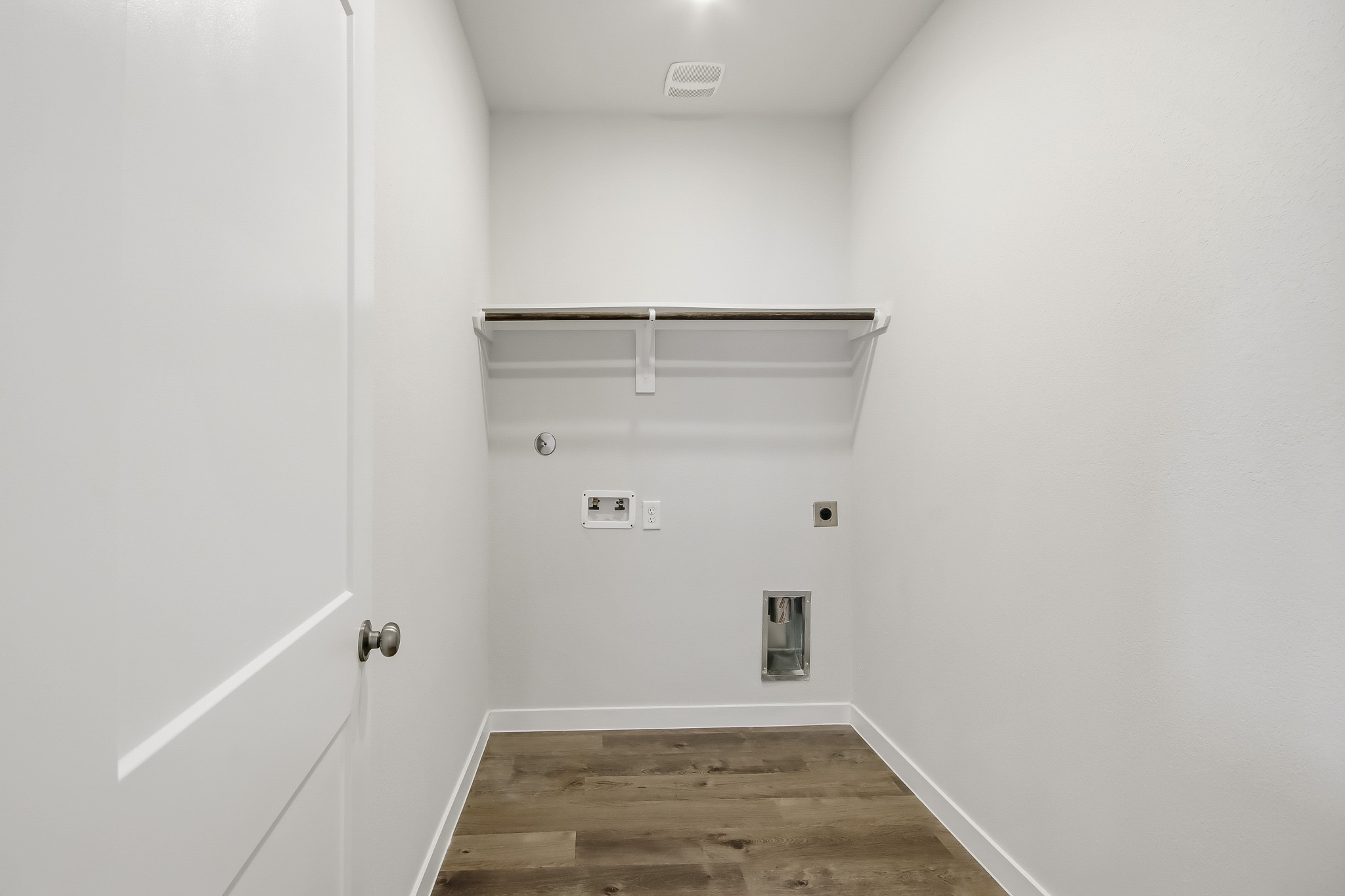 A white room with a wood floor.