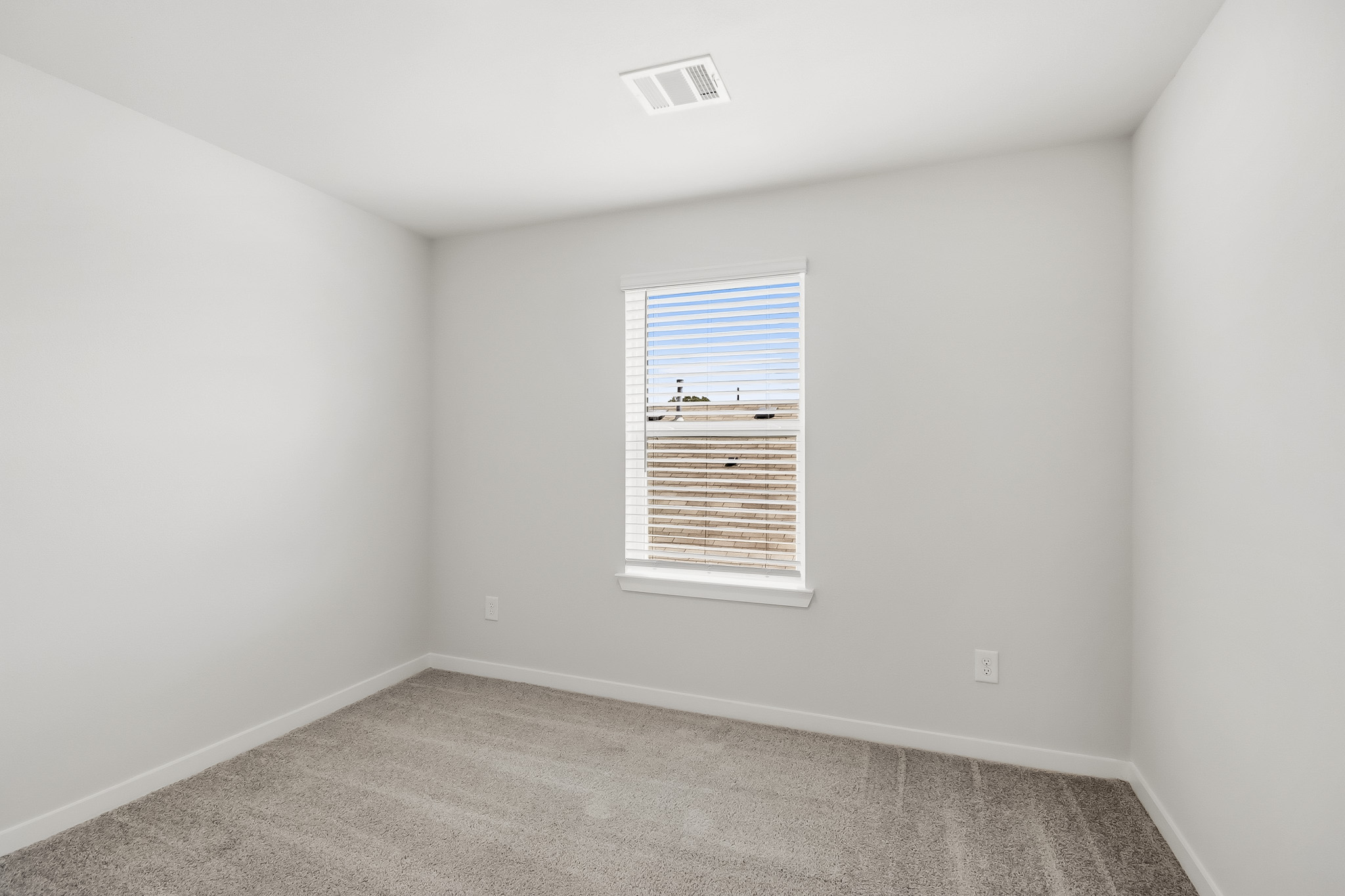 A room with a window and a carpet.