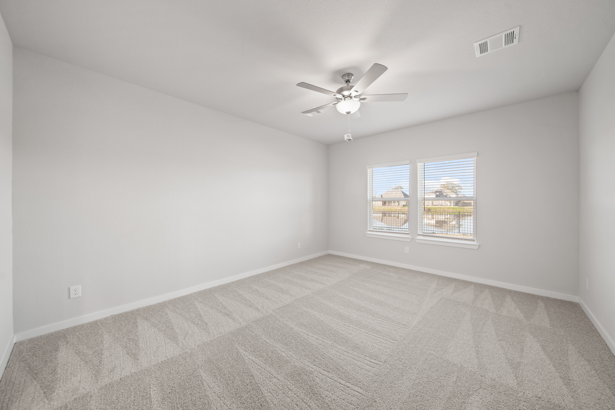A room with a ceiling fan and a window.