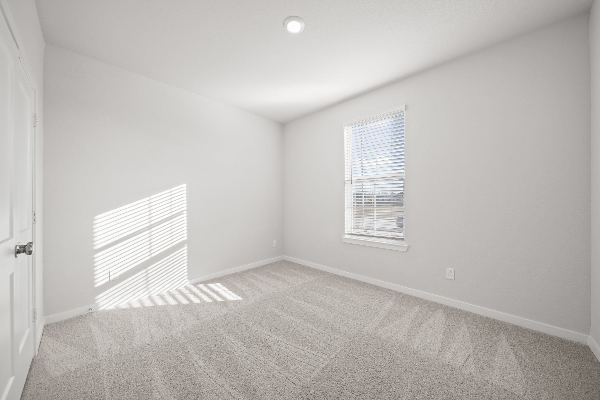 A room with a window and a rug.