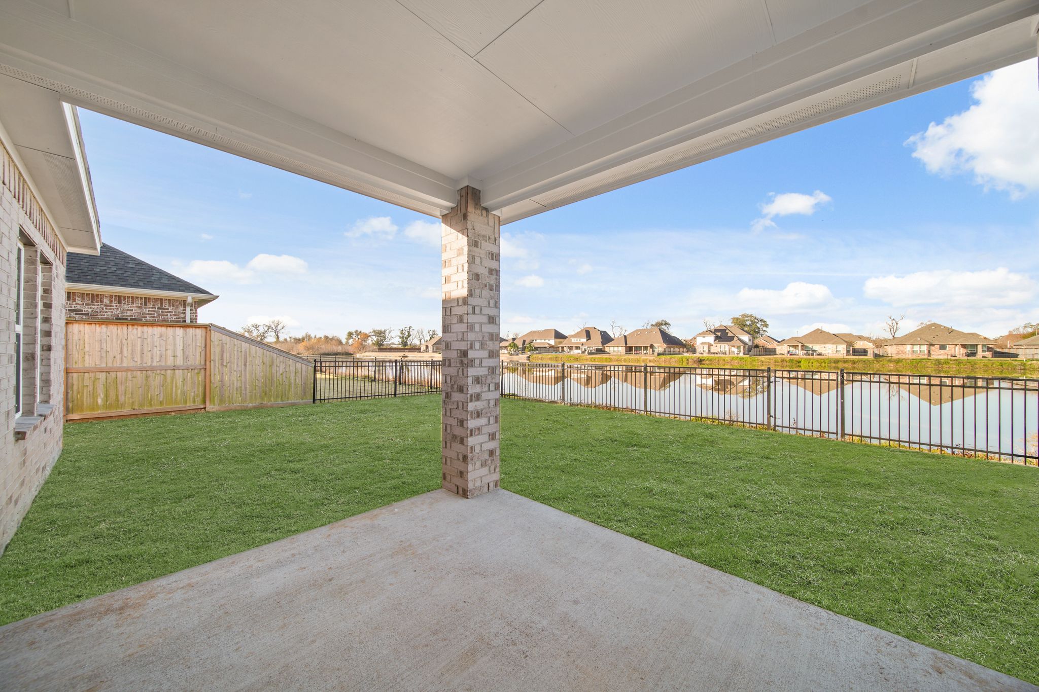 A fenced in yard with a stone structure in the middle.