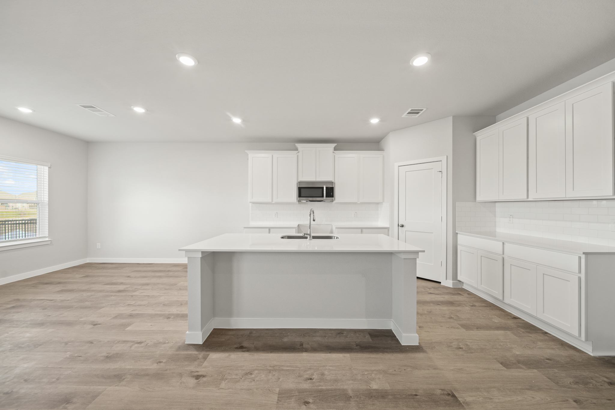 A kitchen with white cabinets.