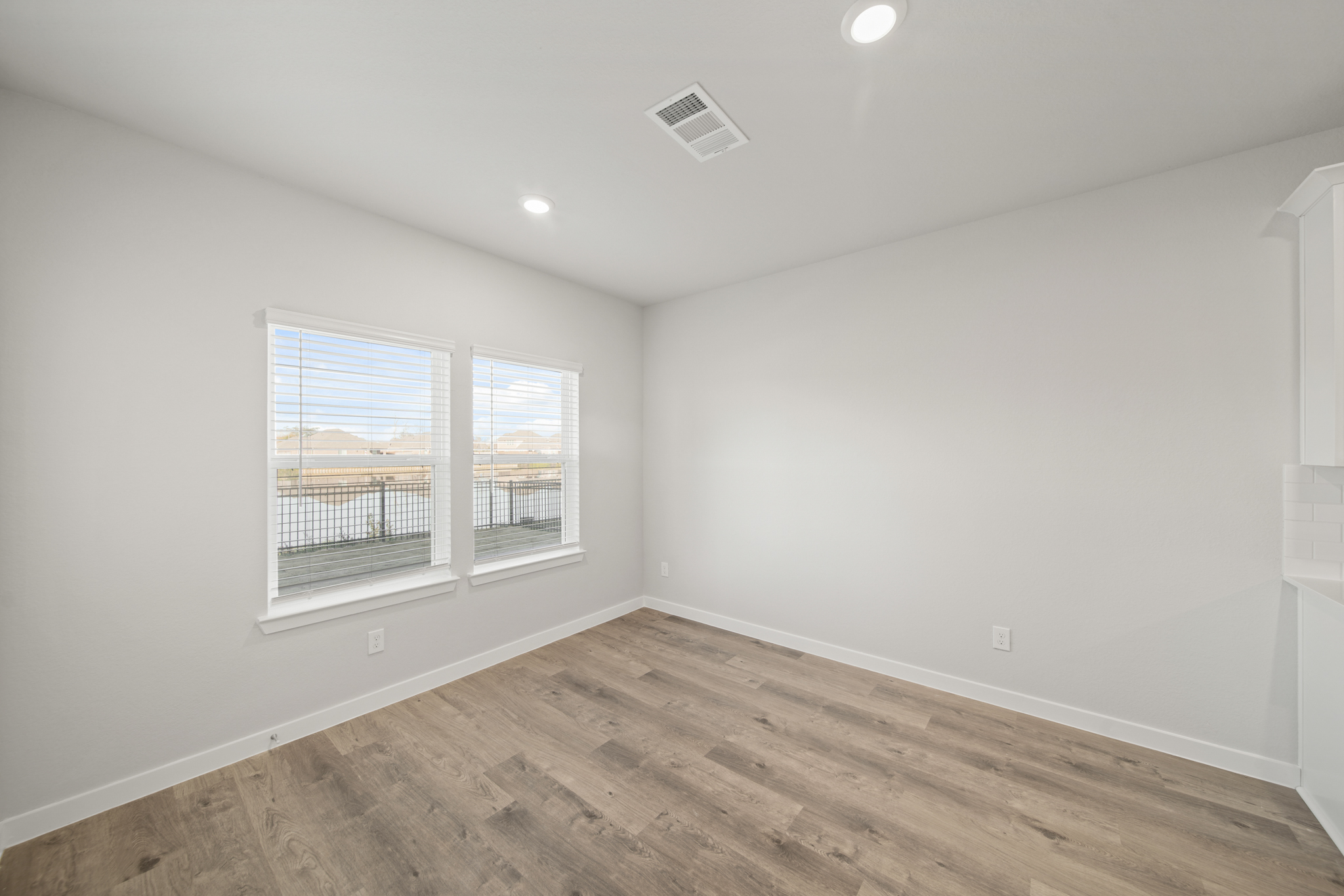 A room with a wood floor and a window with a wood floor.