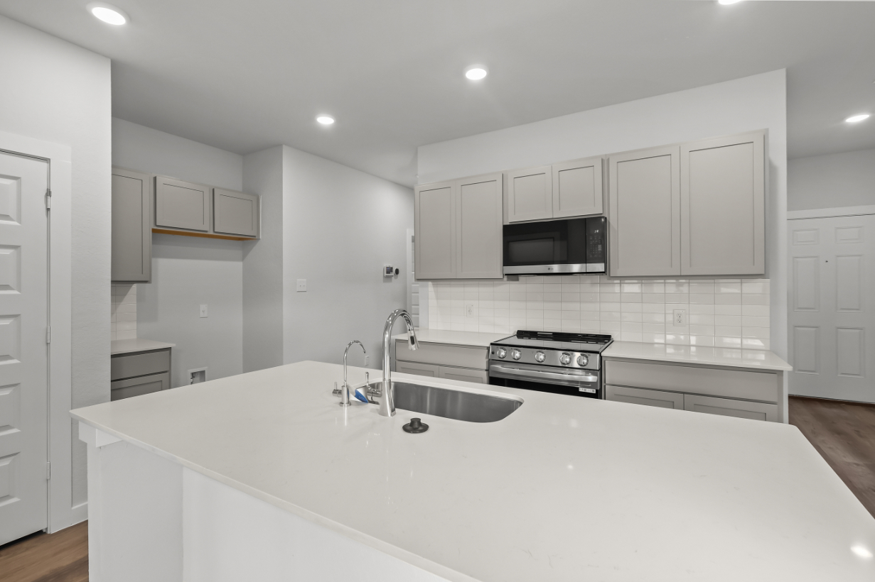 A kitchen with white cabinets.