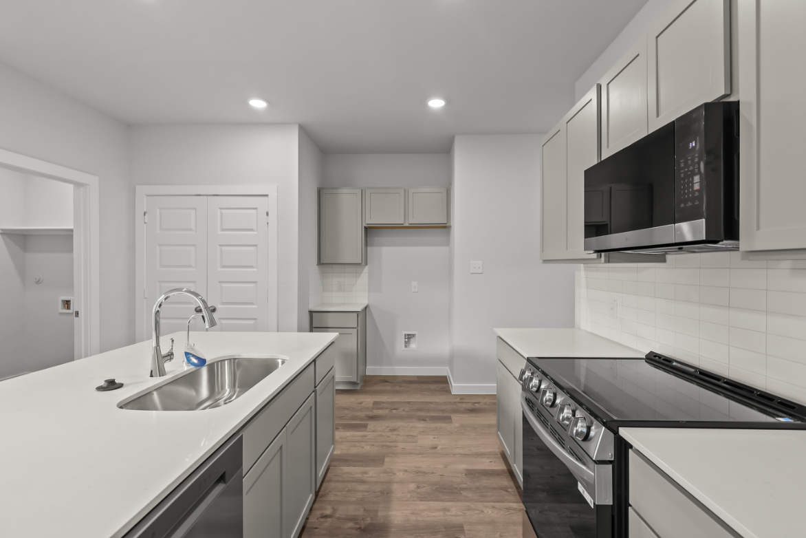 A kitchen with white cabinets.