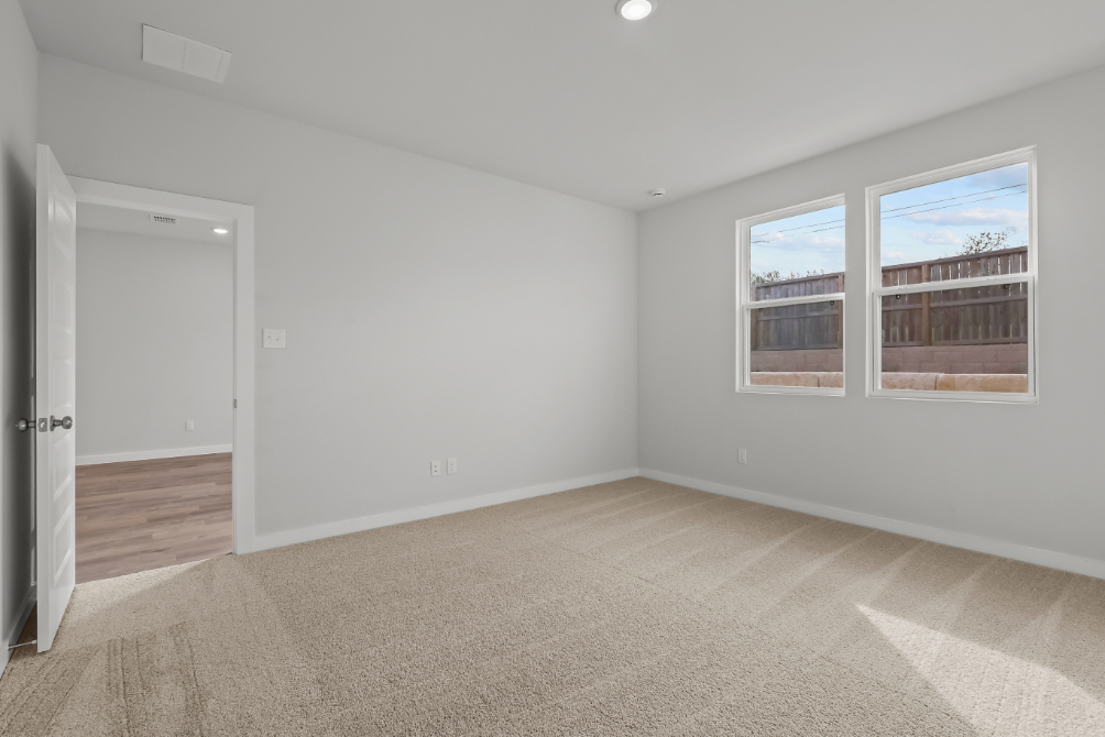 A room with a window and a carpet.